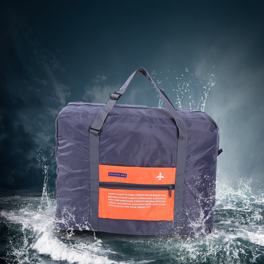 Eine faltbare dunkelgraue Reisetasche mit orangefarbener Fronttasche mit Städtenamen.