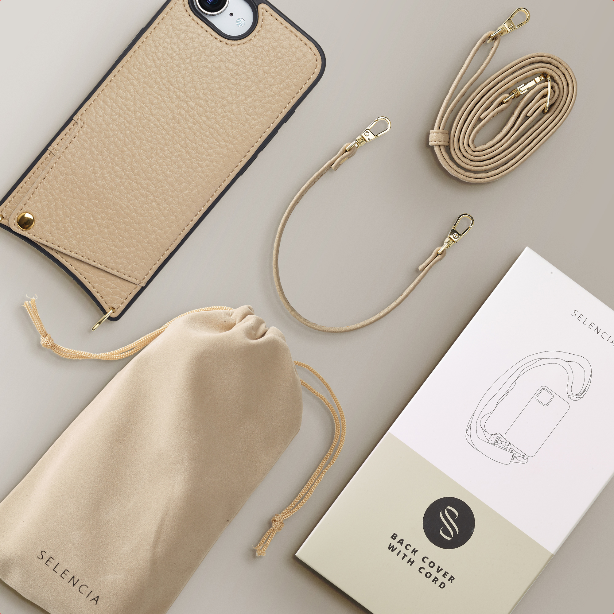 Une coque de téléphone en cuir beige, une pochette, une sangle et un emballage.