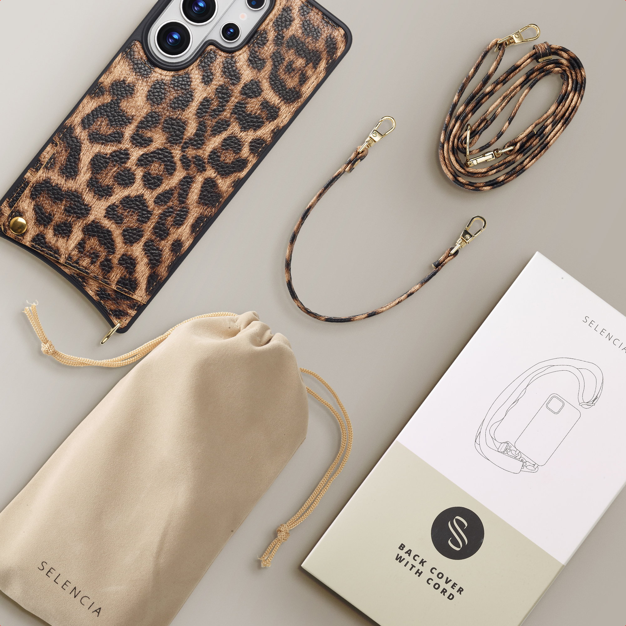 Leopardprint telefoonhoes met koord, stofzak en verpakking op grijze achtergrond.