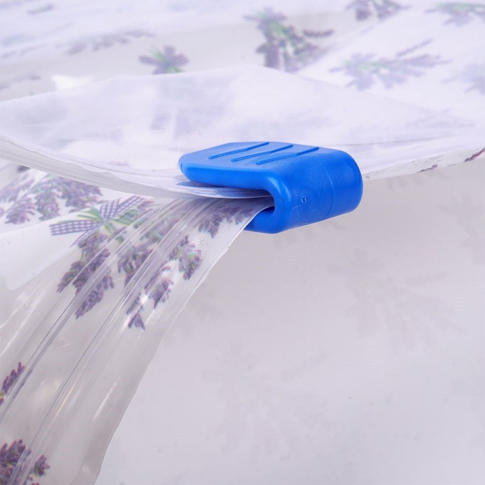 Un clip azul sujeta una lámina de plástico transparente con estampado de lavanda.