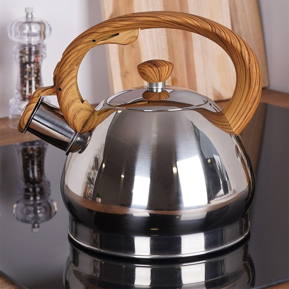 Tetera de acero inoxidable con mango de madera en vitrocerámica.