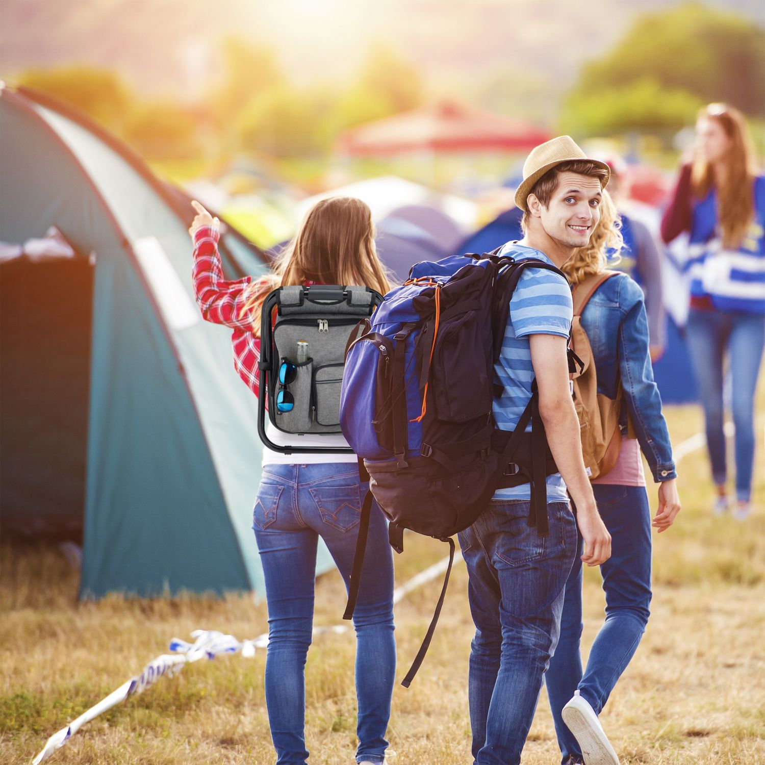 Un grupo de amigos con mochilas en un camping al atardecer.