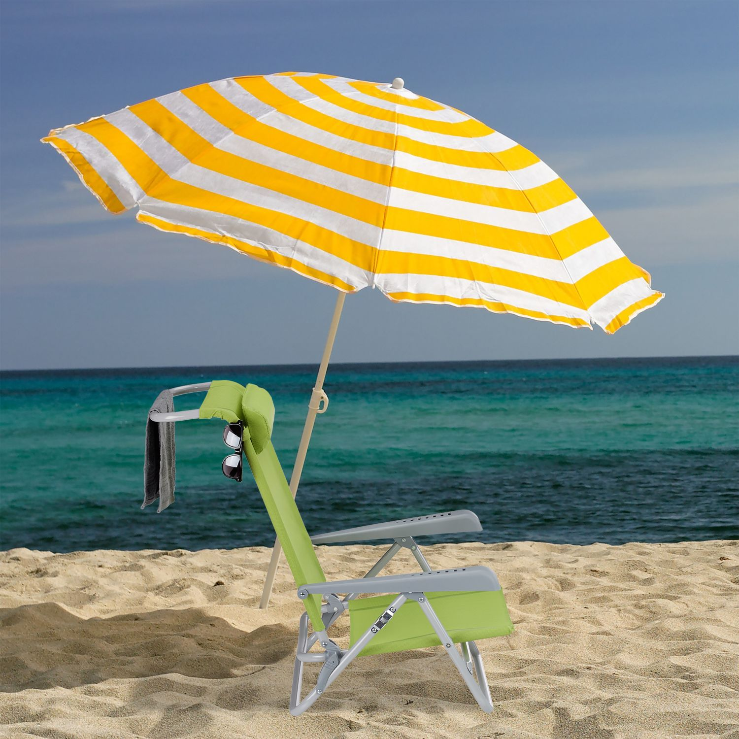 Una silla de playa verde con sombrilla a rayas amarillas y blancas, toalla y gafas.