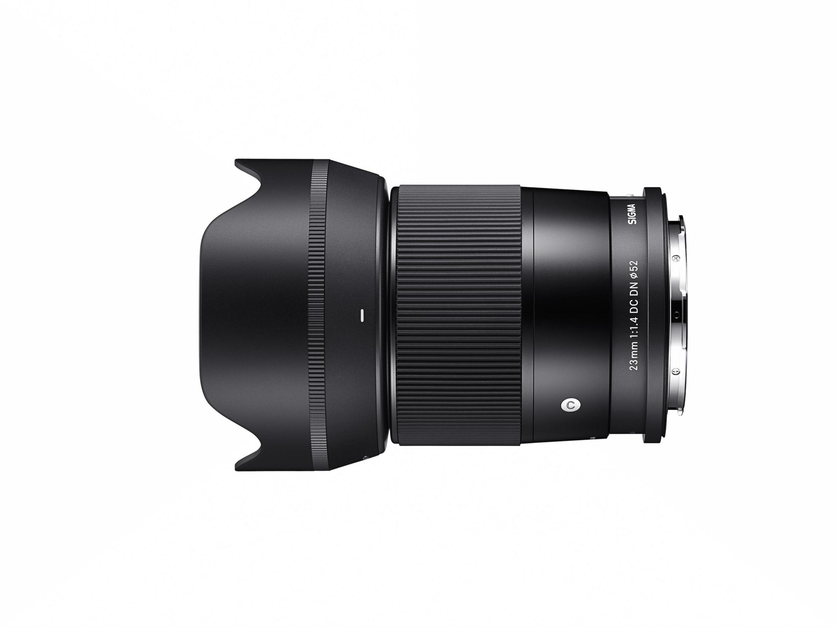 Een zwarte Sigma 23mm 1:1,4 DC DN lens met zonnekap, op witte achtergrond.