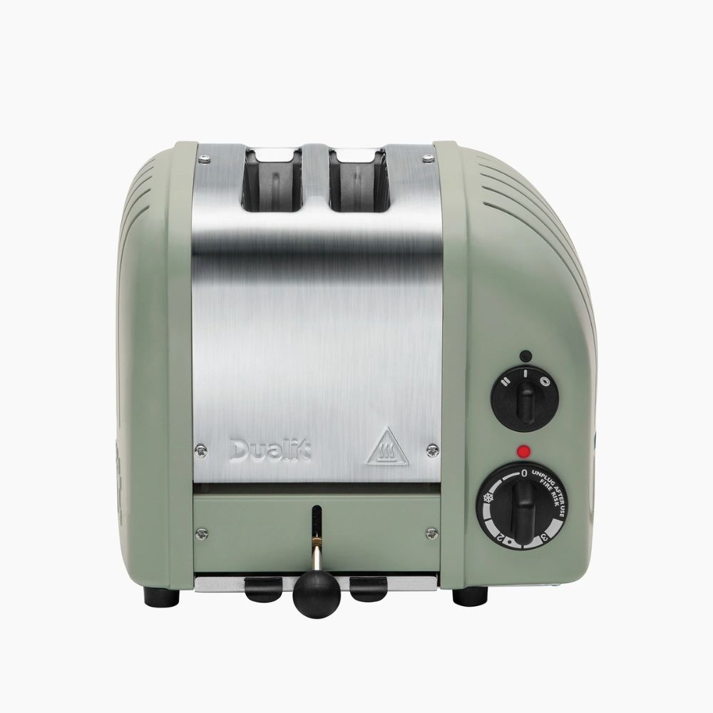 Ein grüne zweischlitzige Toaster mit silberner Front und schwarzem Hebel.