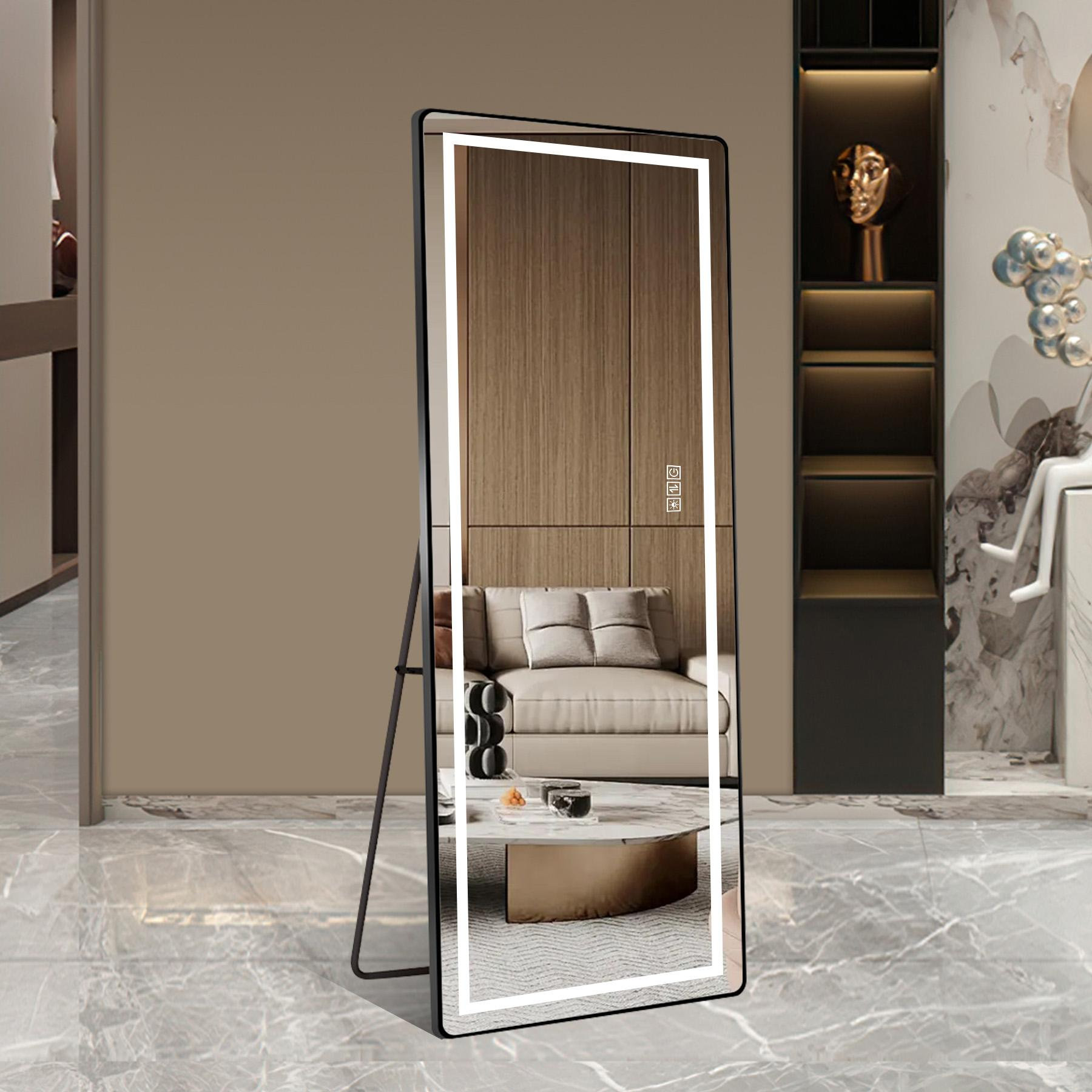 Ein beleuchteter Standspiegel reflektiert ein Sofa, einen Couchtisch und Holzwände.
