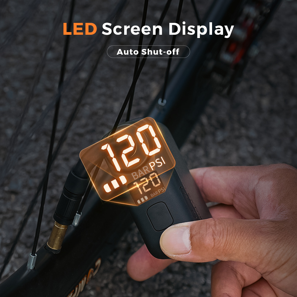 Una mano tiene una pompa d'aria nera con display digitale che mostra 120 PSI.