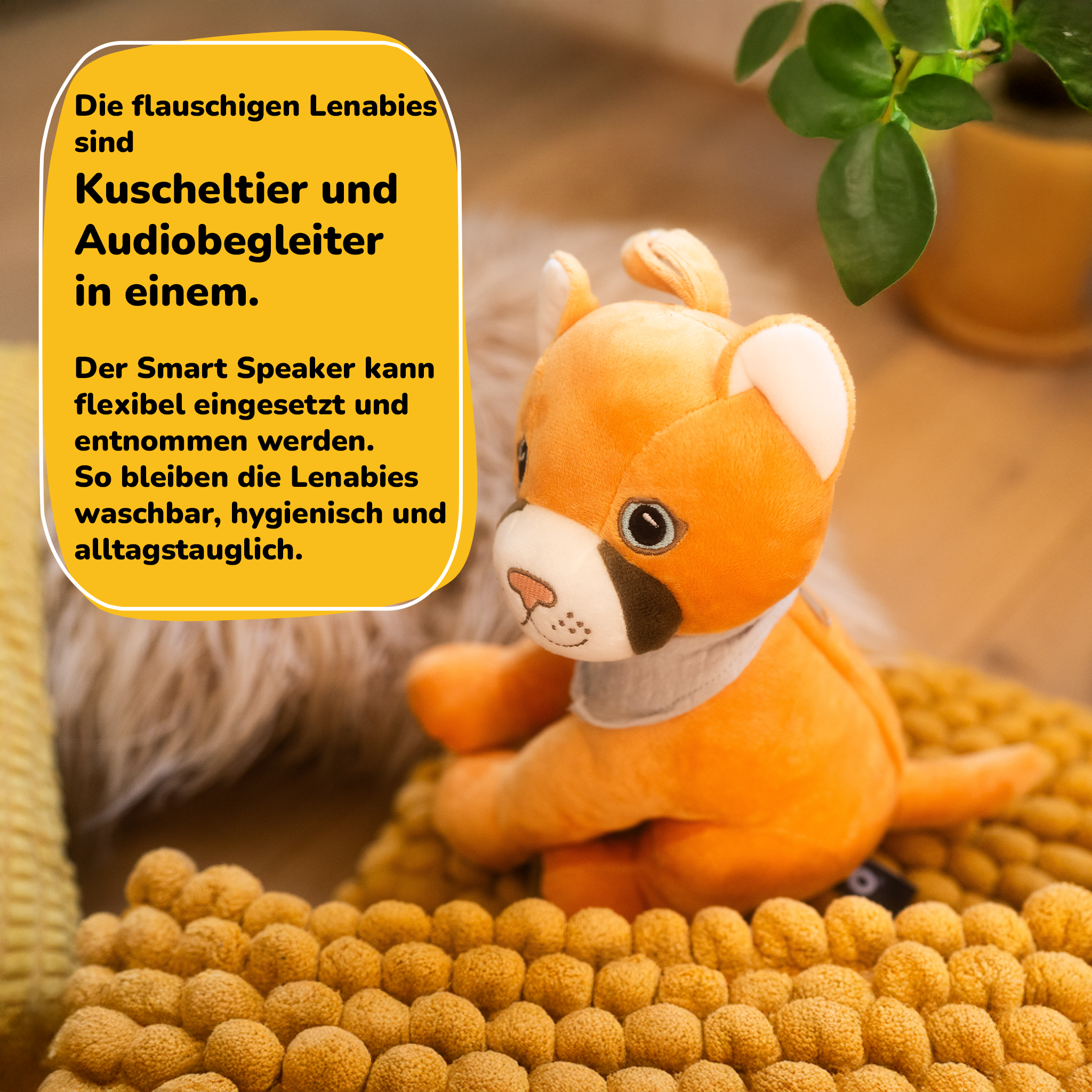 Ein orangefarbenes Stofftier sitzt auf einer gelben Decke. Text auf Deutsch.