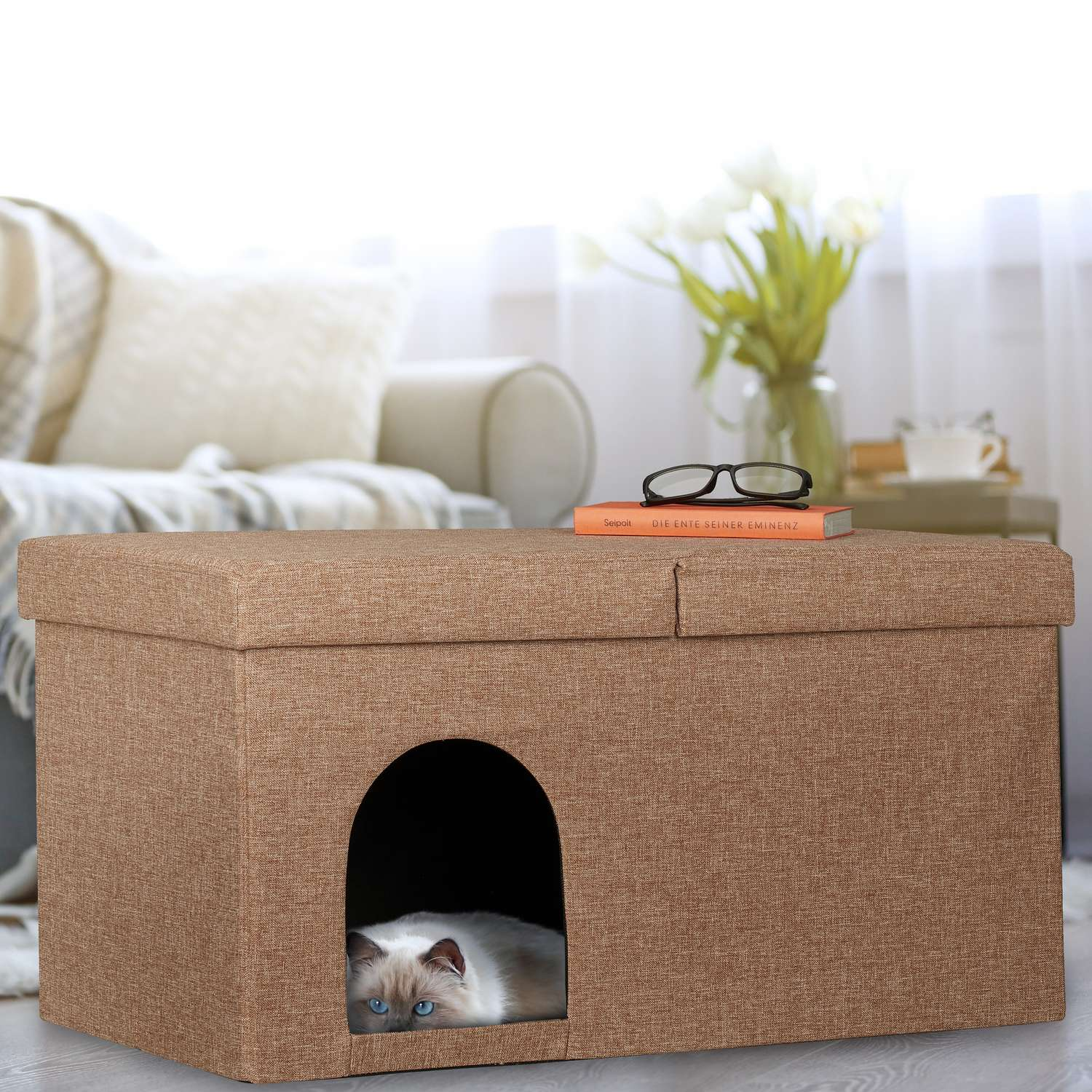 Un cubo para gatos beige con entrada arqueada, un gato dentro.