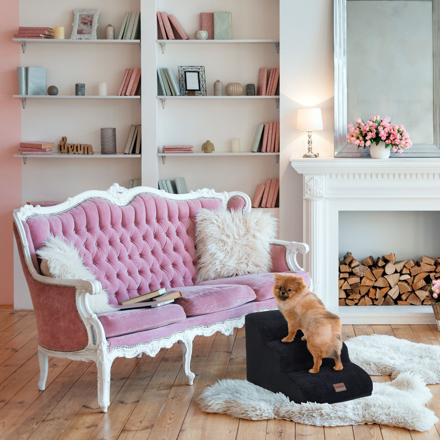 Un Pomerania se sube a una escalera para perros negra frente a un sofá rosa.