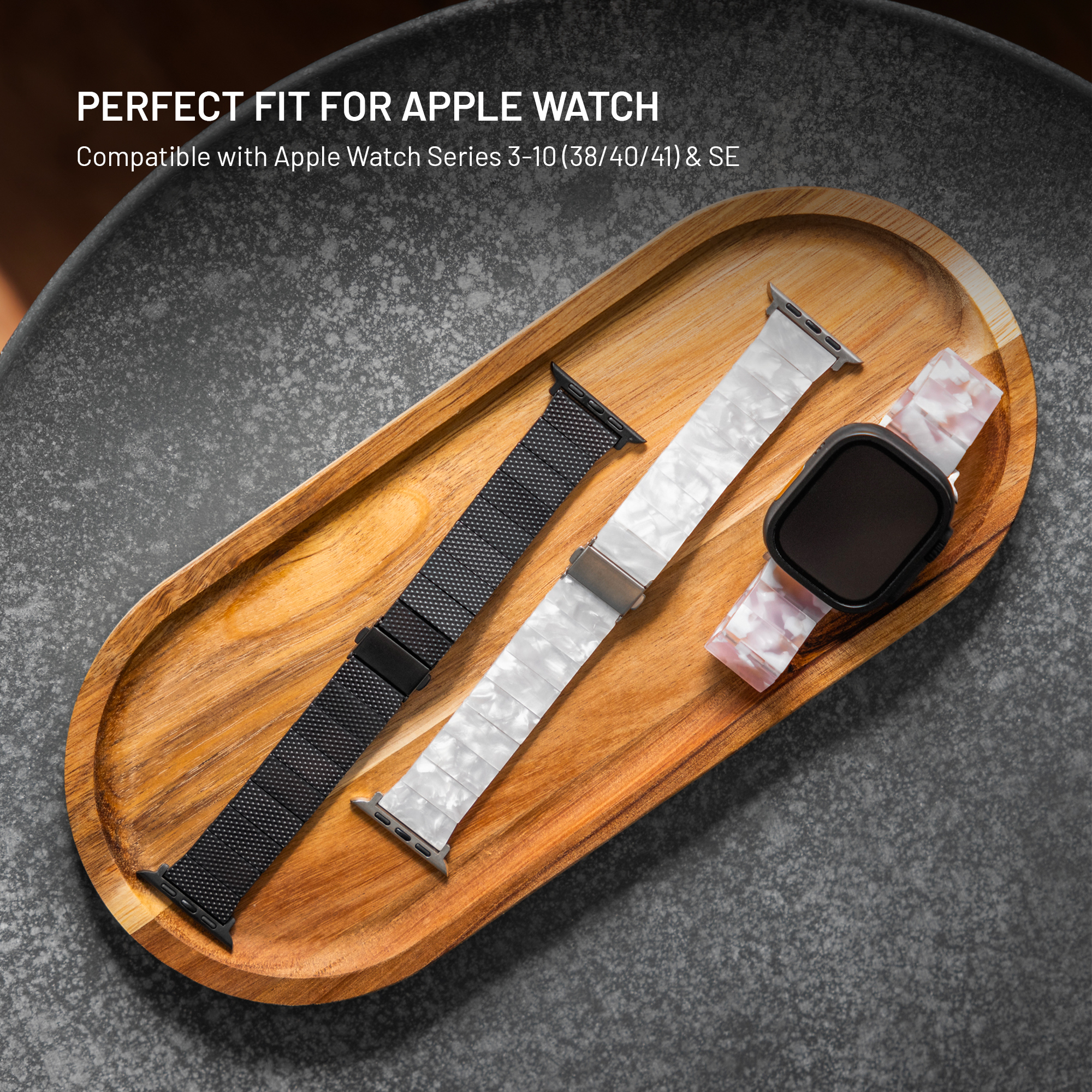 Drei Apple Watch Armbänder: Schwarz, Weiß und Pink Marmoriert, auf Holzschale.