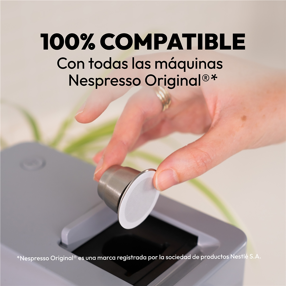 Una mano introduce una cápsula de café en una cafetera.