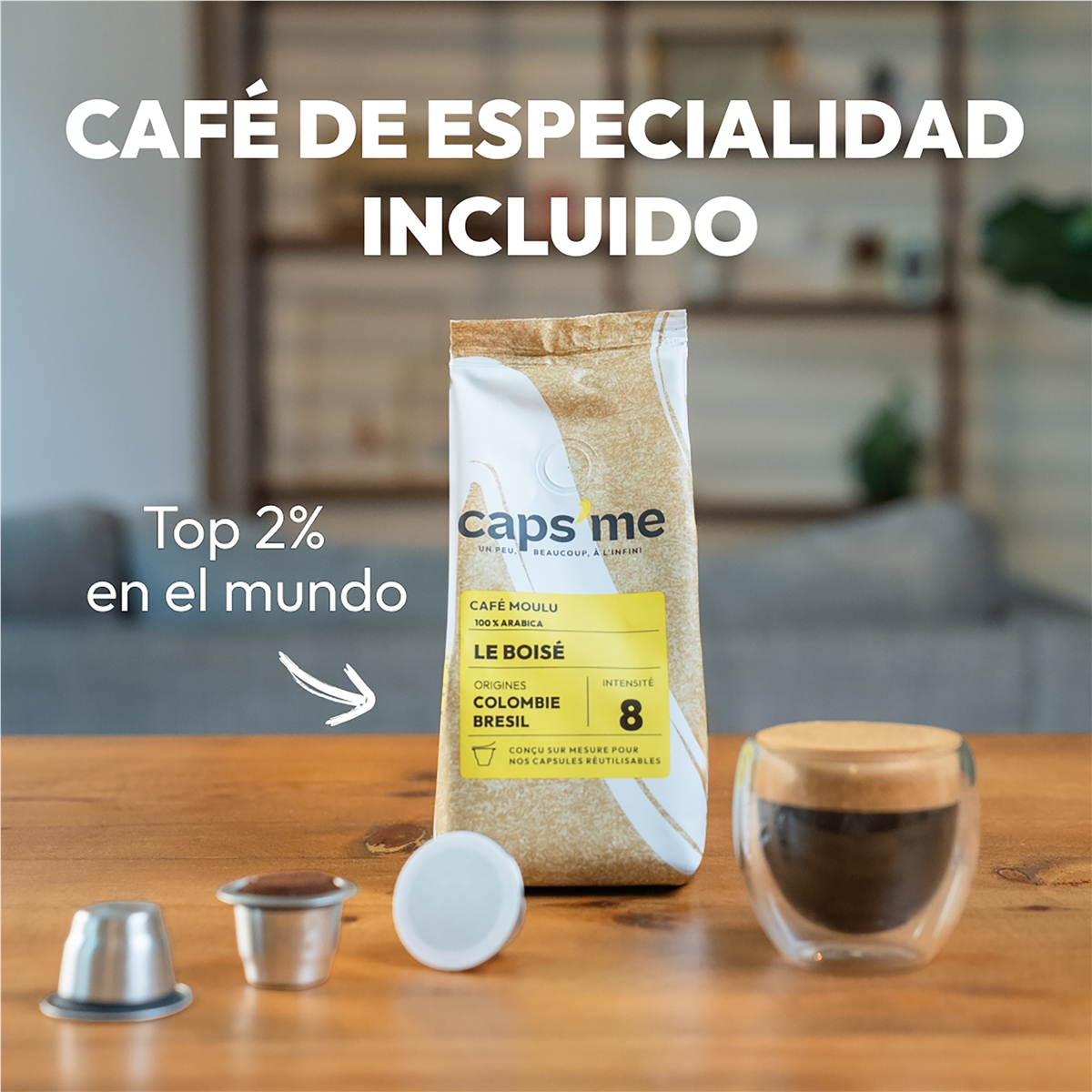 Bolsa de café con cápsulas y taza en mesa de madera. "Café de especialidad incluido".