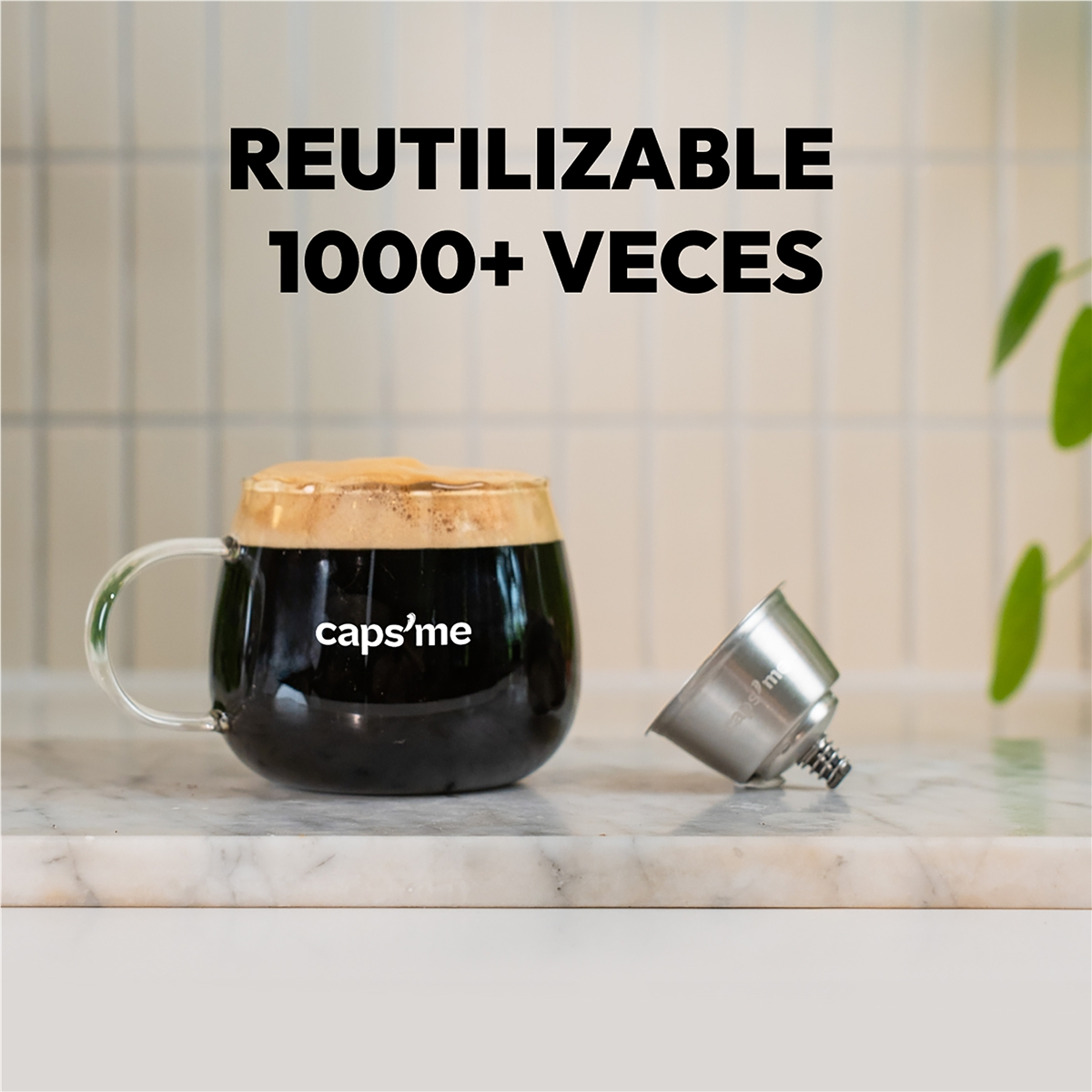 Taza de vidrio con café y espuma, junto a una cápsula de café de metal.
