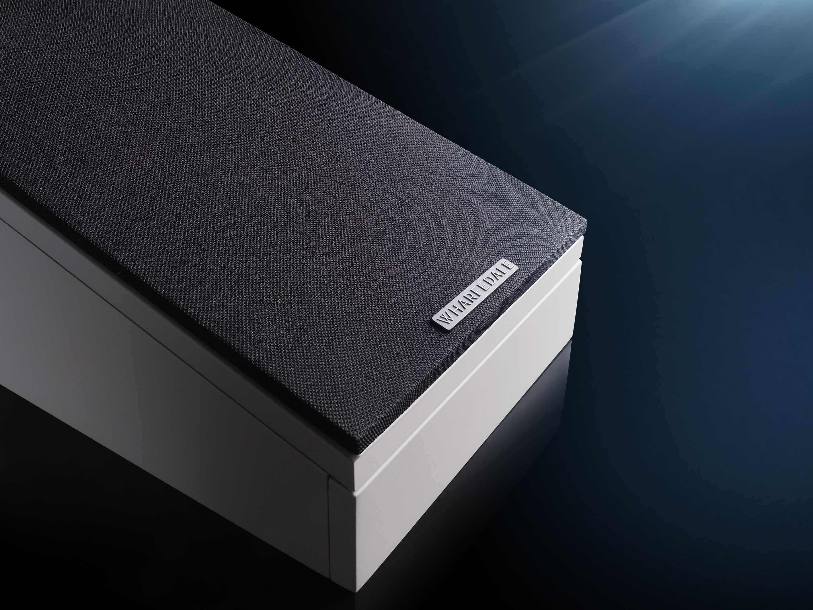 A white speaker with a black fabric top and a Wharfedale logo.
