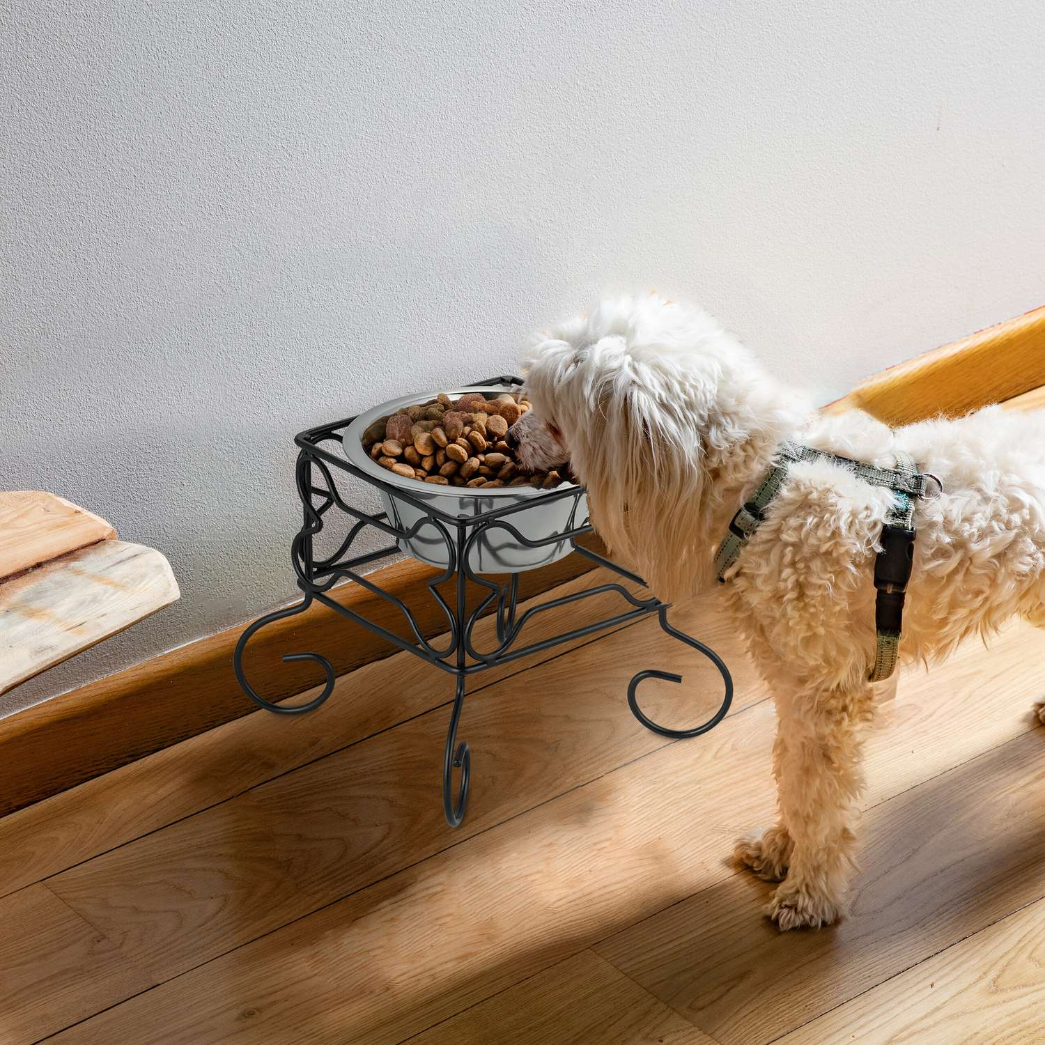 Un perro blanco come de un cuenco en un soporte.