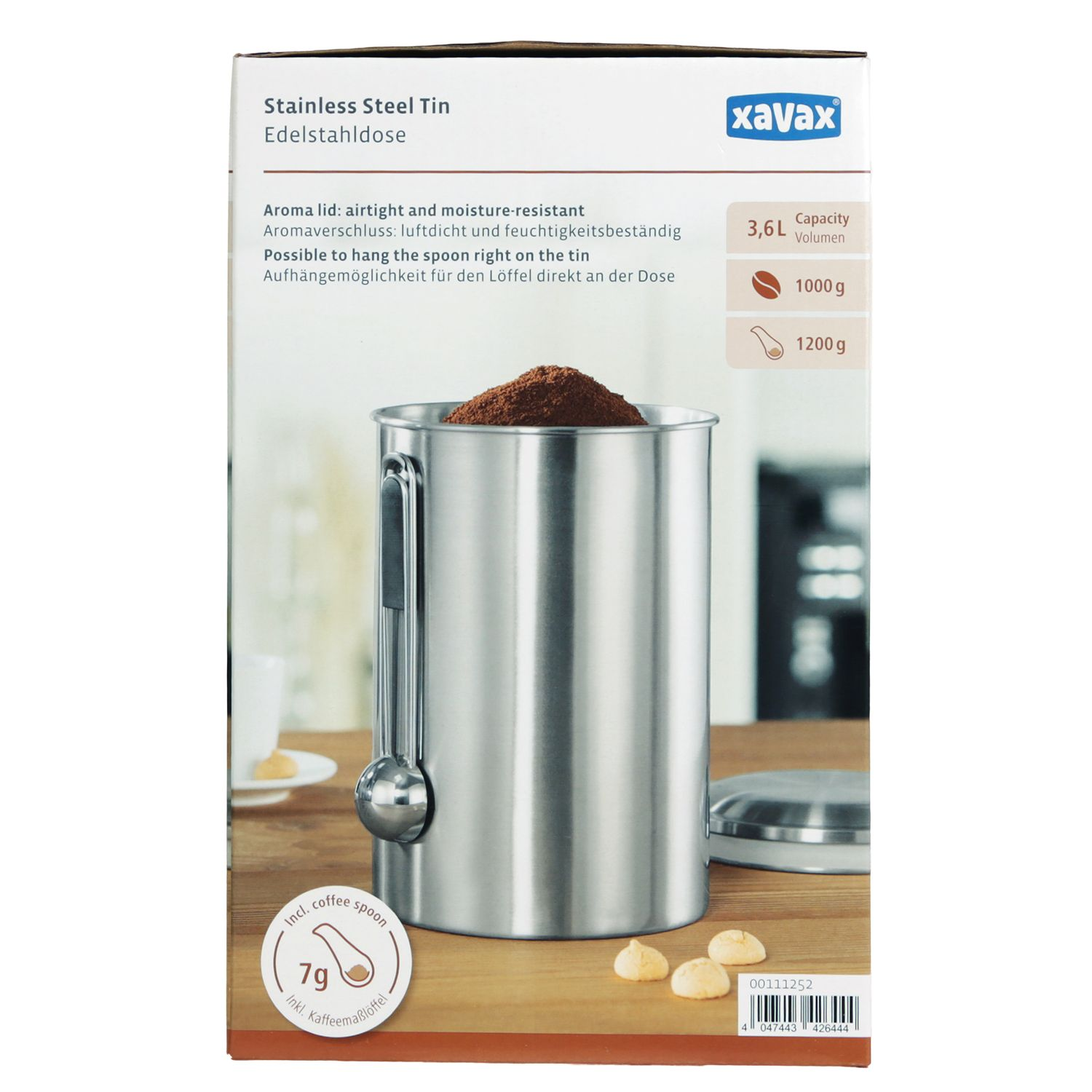 Edelstahl-Kaffeedose mit Löffel, gefüllt mit Kaffeepulver, auf Holztisch.