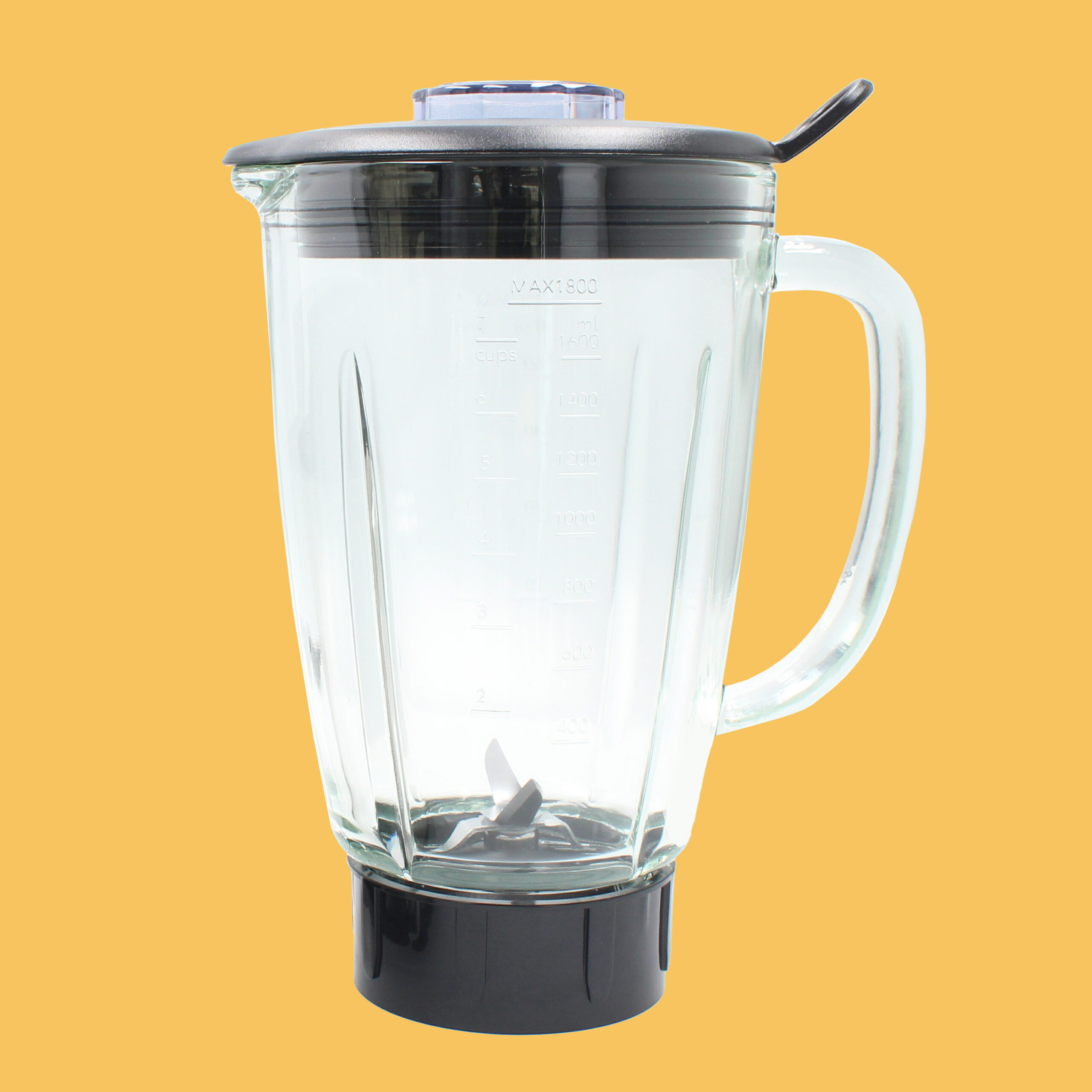 Ein Glasmixerbehälter mit schwarzem Deckel, Griff und Basis, auf gelbem Hintergrund.