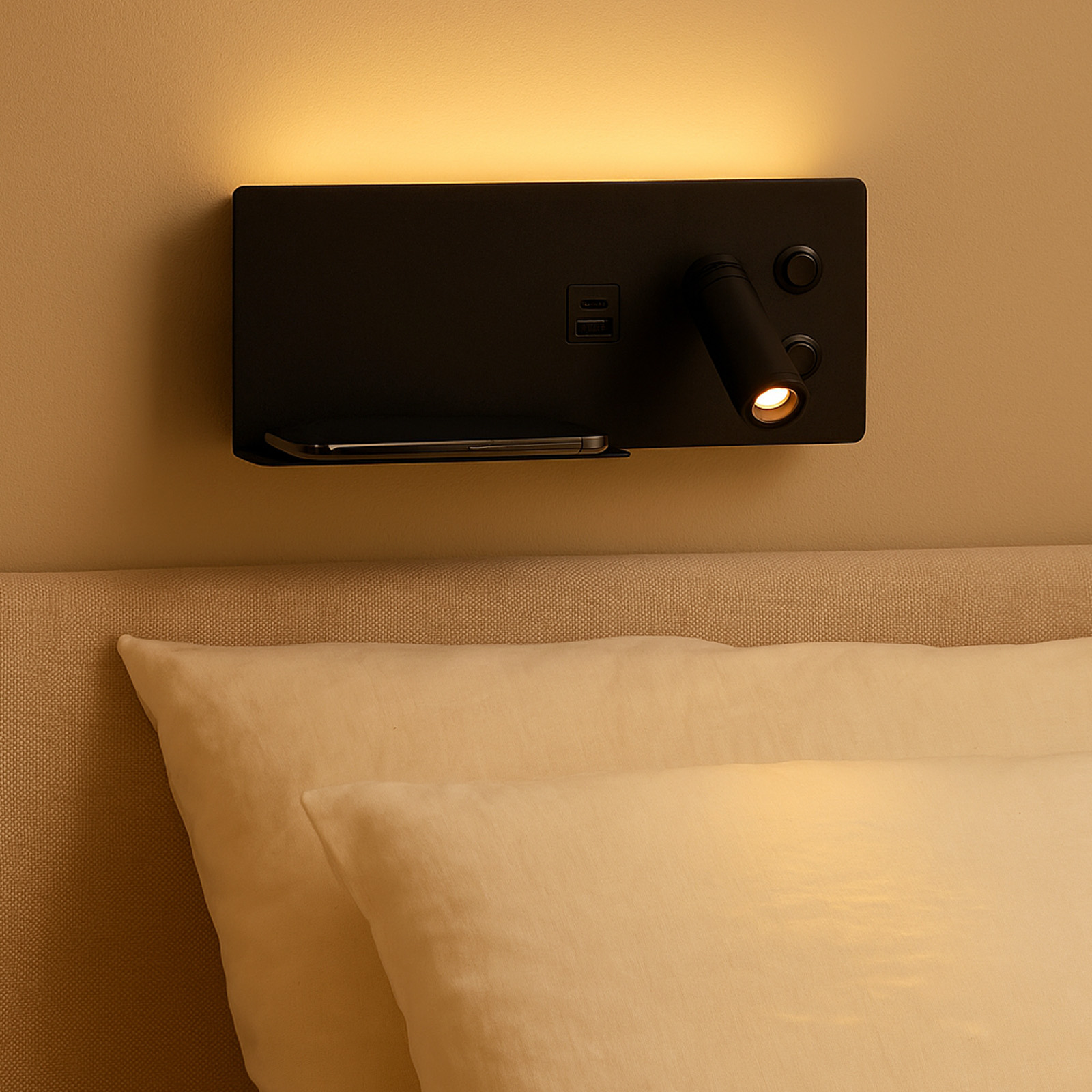 Aplique de pared negro con puerto de carga, estante y foco ajustable sobre una cama.