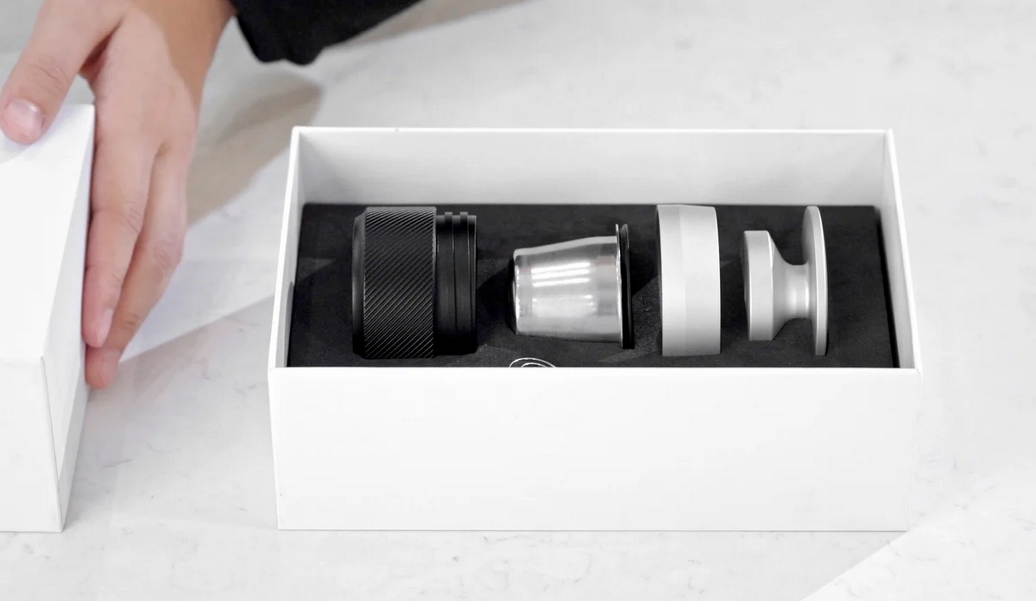 Czarny i trzy srebrne części w białym pudełku.