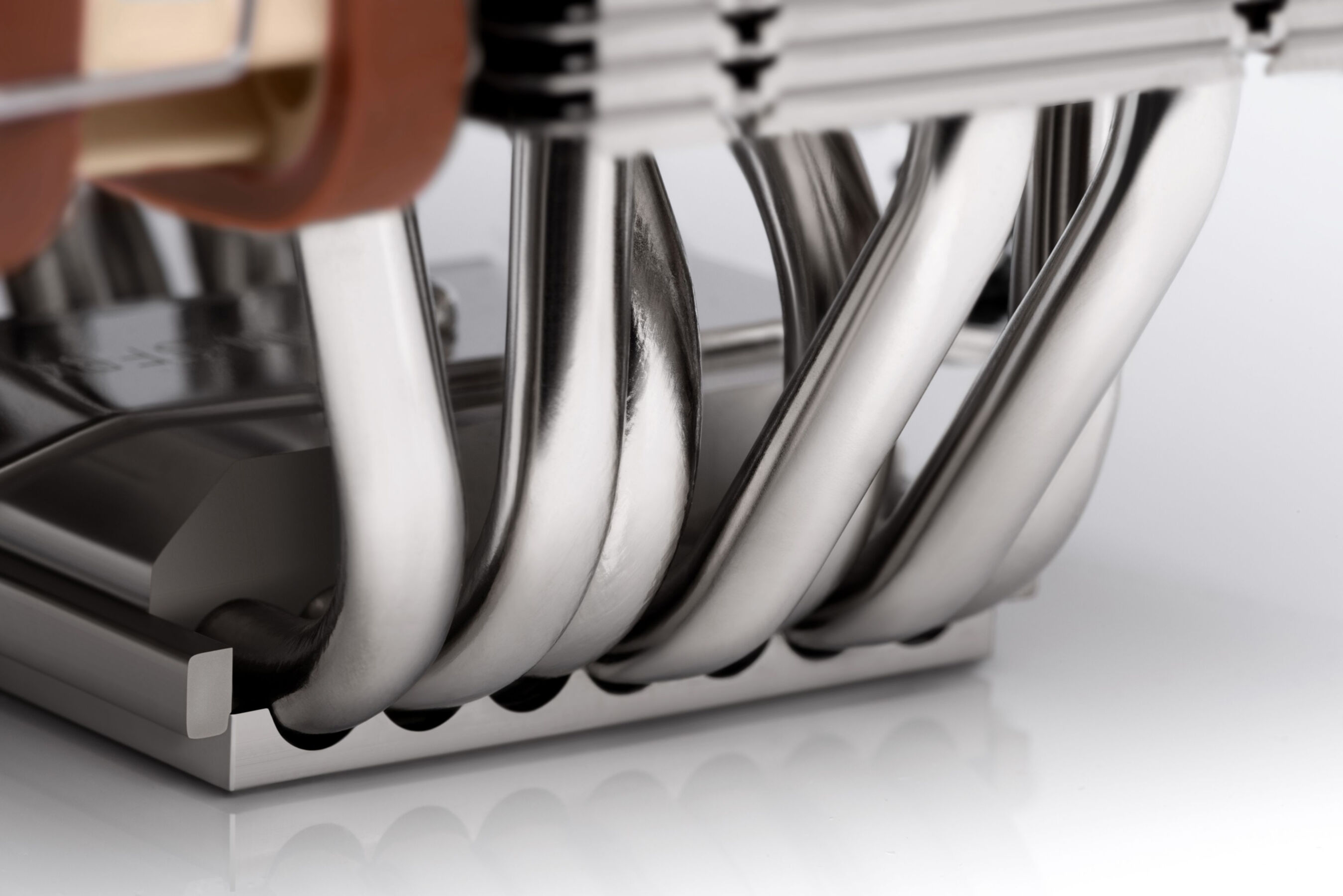 Metalowy cooler CPU z miedzianymi rurkami cieplnymi i wspornikiem wentylatora.