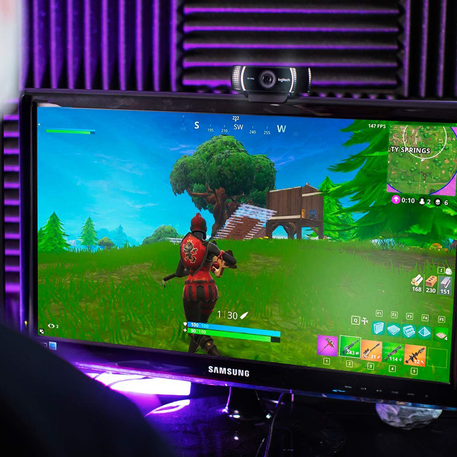 Un joueur joue à Fortnite sur un écran éclairé en violet.