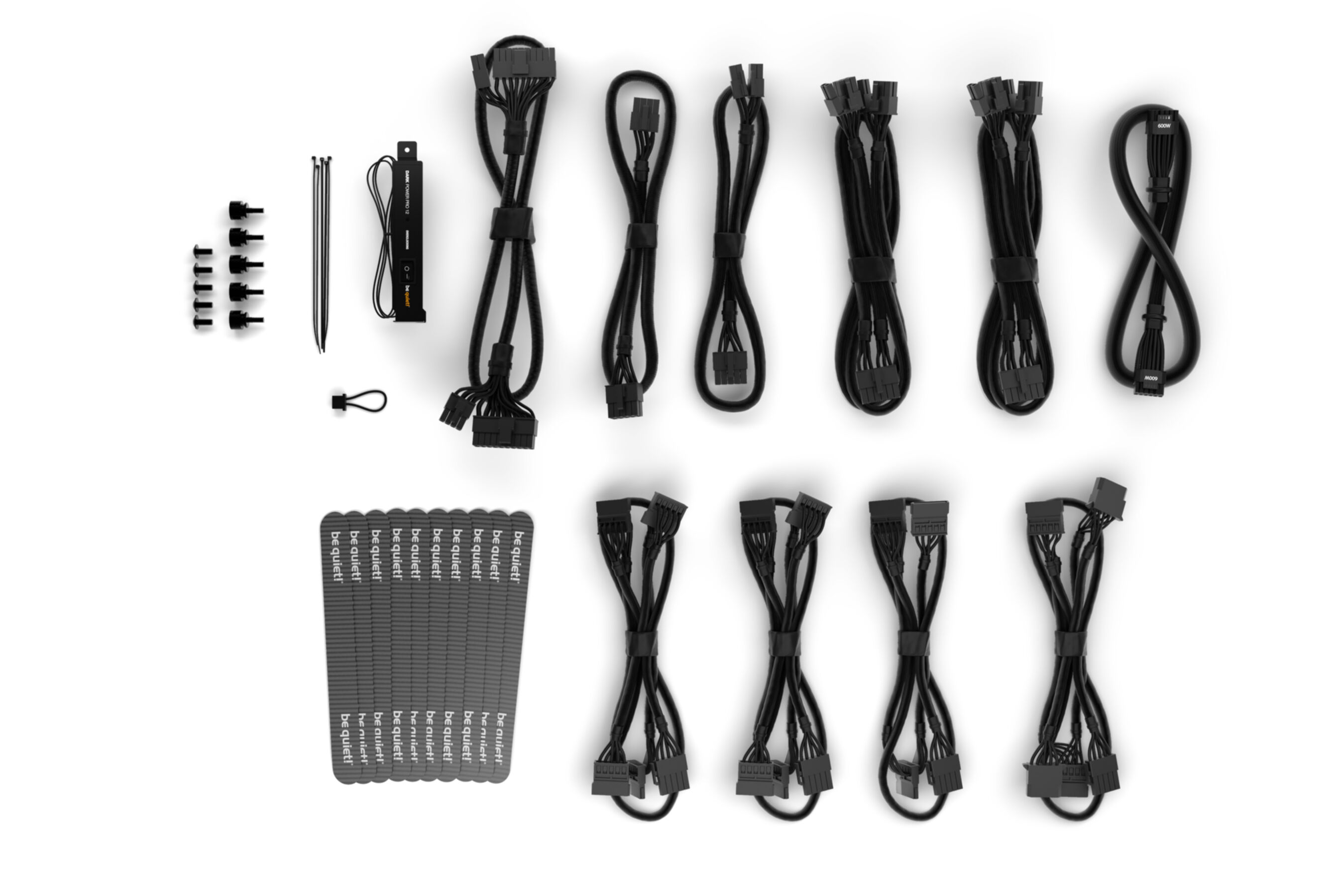 Czarne kable komputerowe, śruby, opaski kablowe i moduł zasilający na białym tle.