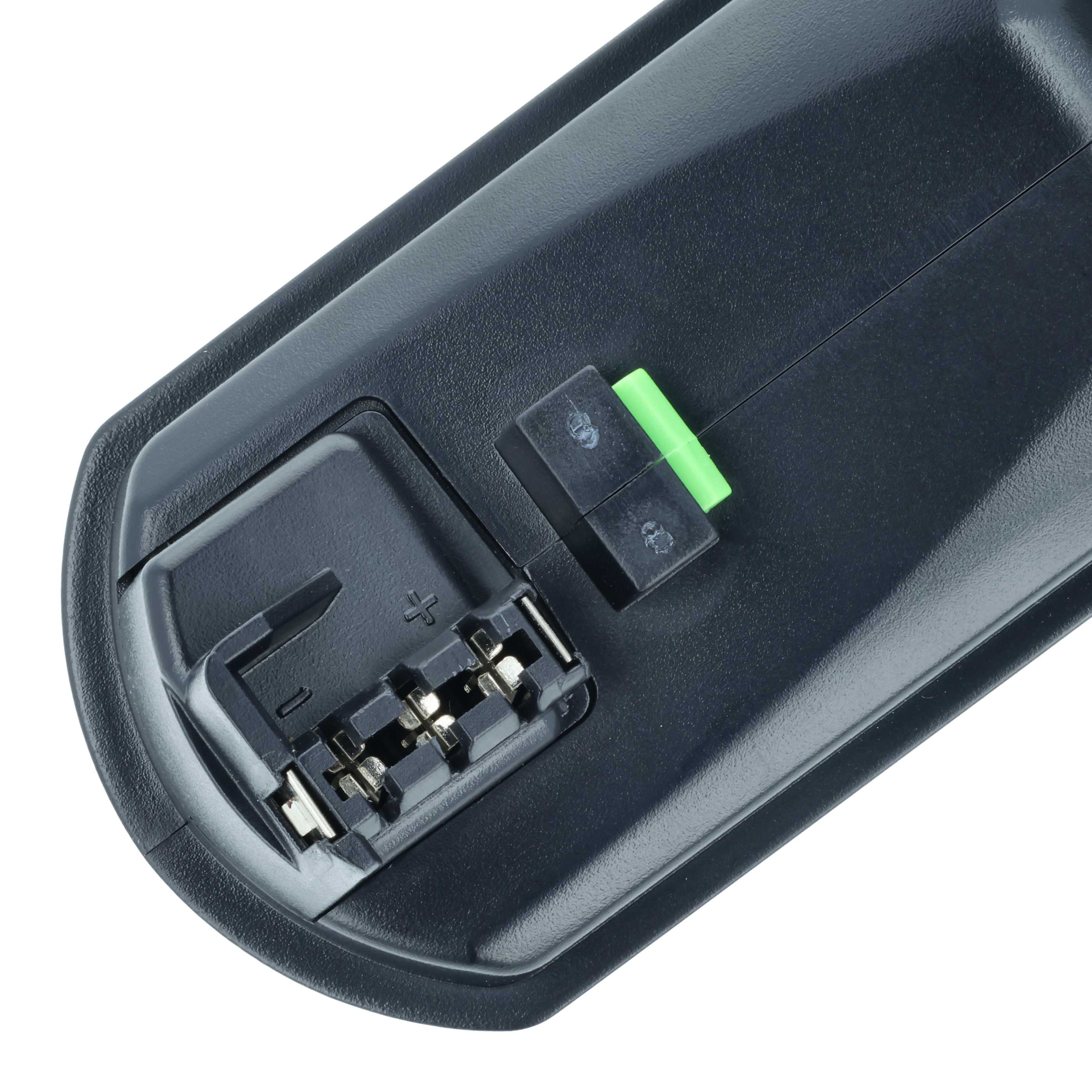 Nahaufnahme eines schwarzen Batteriefachs mit Metallkontakten und einem grünen Schalter.