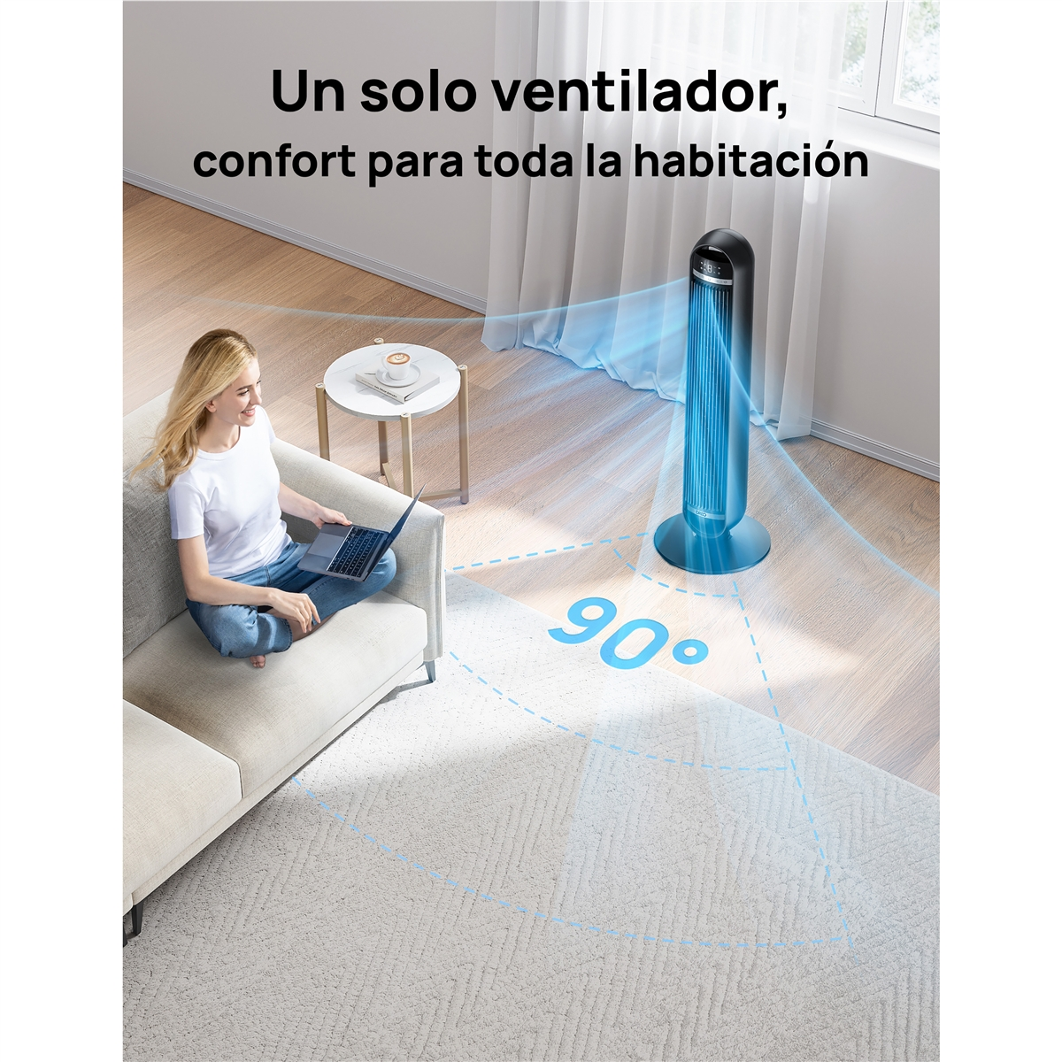 Una mujer se sienta en un sofá con un portátil. Un ventilador de torre circula aire.