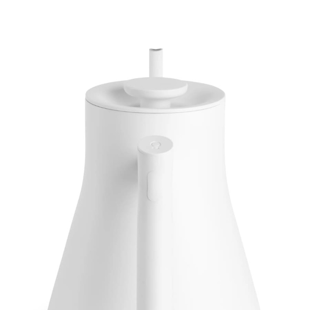 Zbliżenie białego czajnika z uchwytem i pokrywką na białym tle.