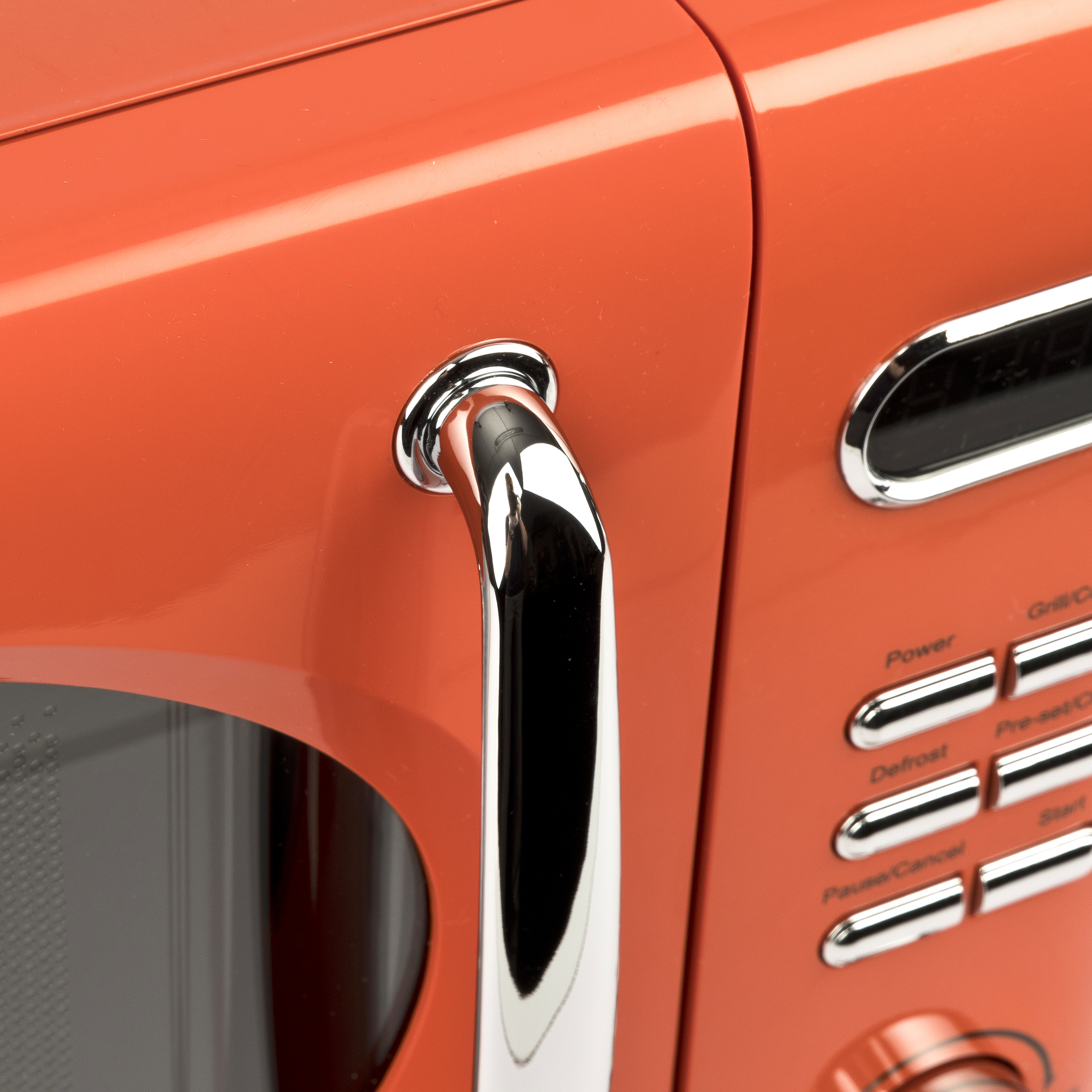 Pomarańczowa kuchenka mikrofalowa z chromowanym uchwytem i panelem sterowania.