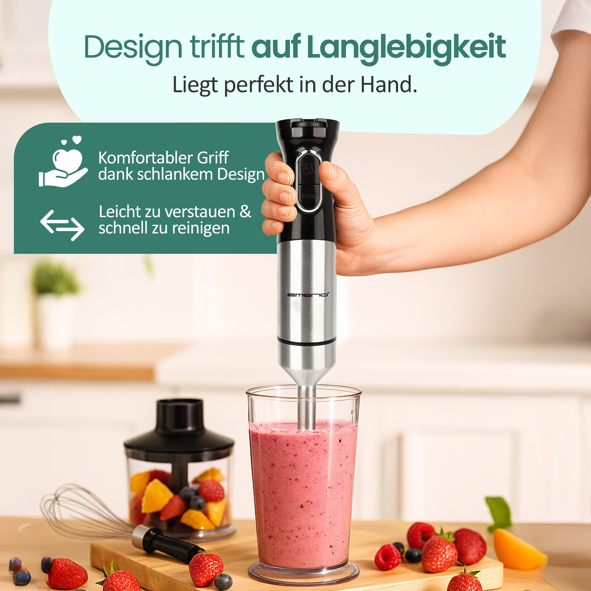 Ein Stabmixer mixt einen Beeren-Smoothie in einem Glas. Früchte und Zubehör liegen daneben.