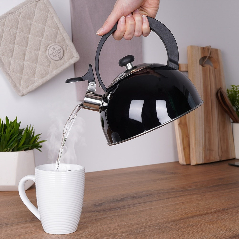 Una mano vierte agua caliente de una tetera negra en una taza blanca. El vapor sube.