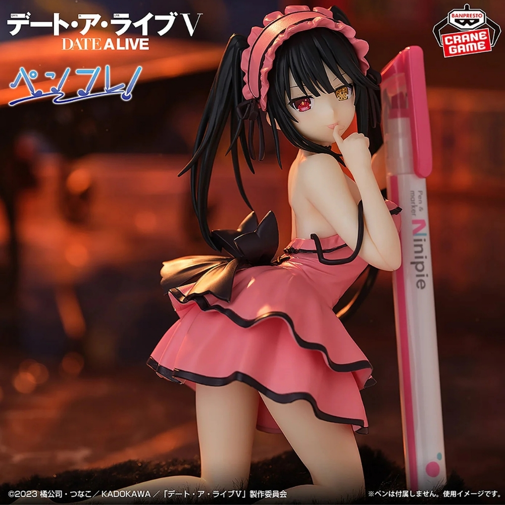 Statua di ragazza anime in vestito rosa accanto a una penna.