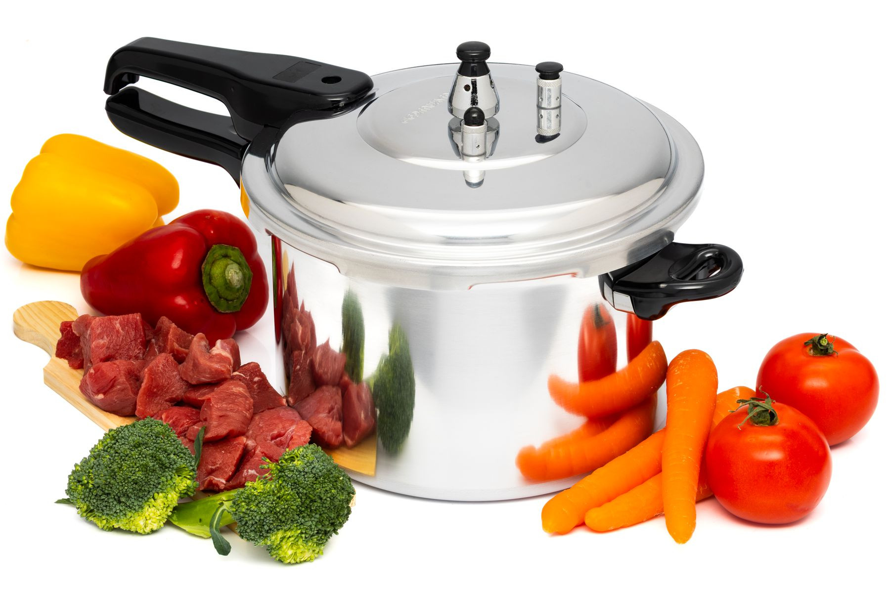 Una olla a presión brillante con carne cruda, brócoli, zanahorias, pimientos y tomates.