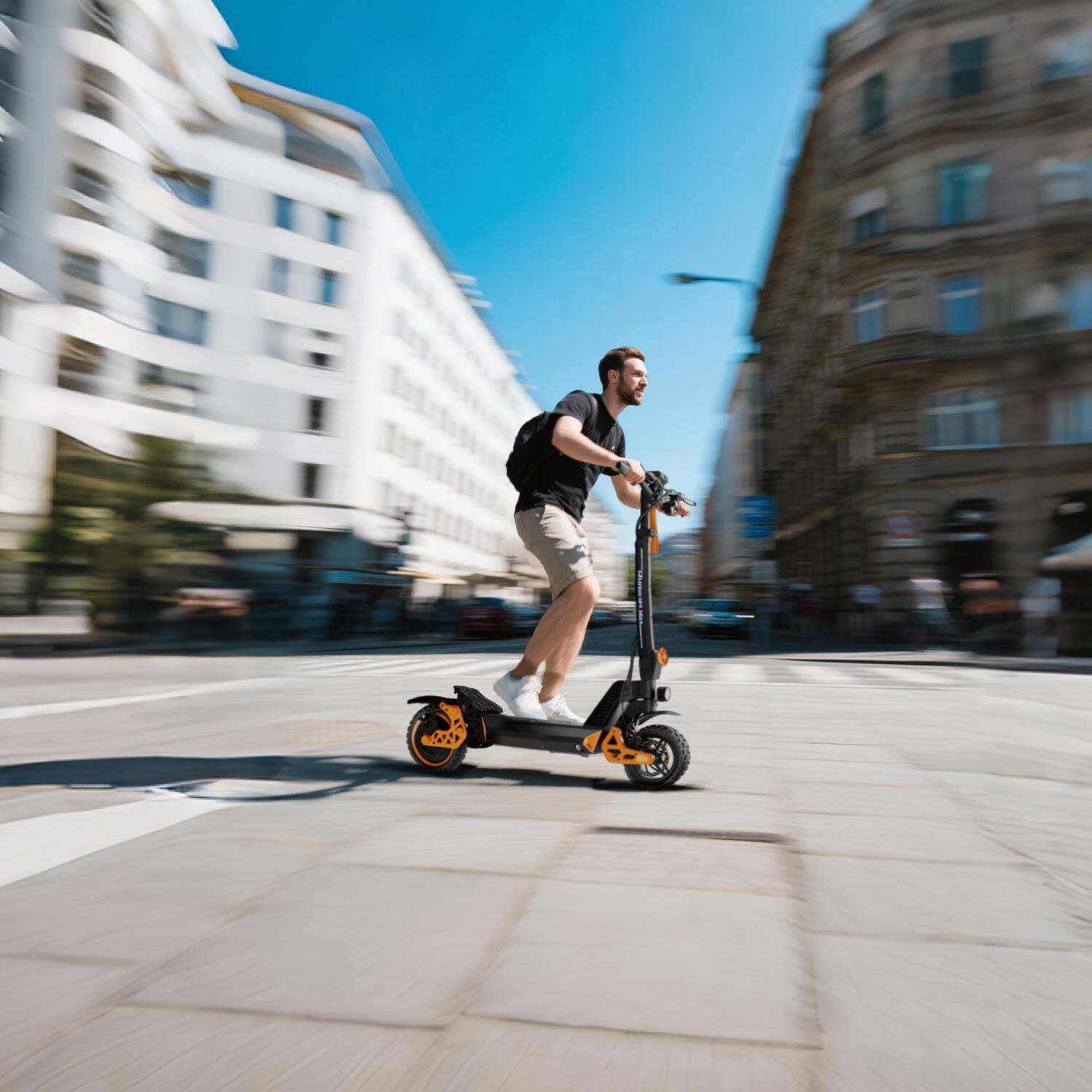 Mężczyzna jedzie na hulajnodze elektrycznej po mieście, budynki w tle.
