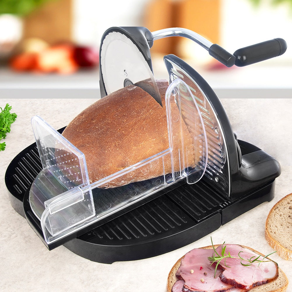 Cortadora eléctrica de pan cortando una hogaza, con sándwiches abiertos cerca.
