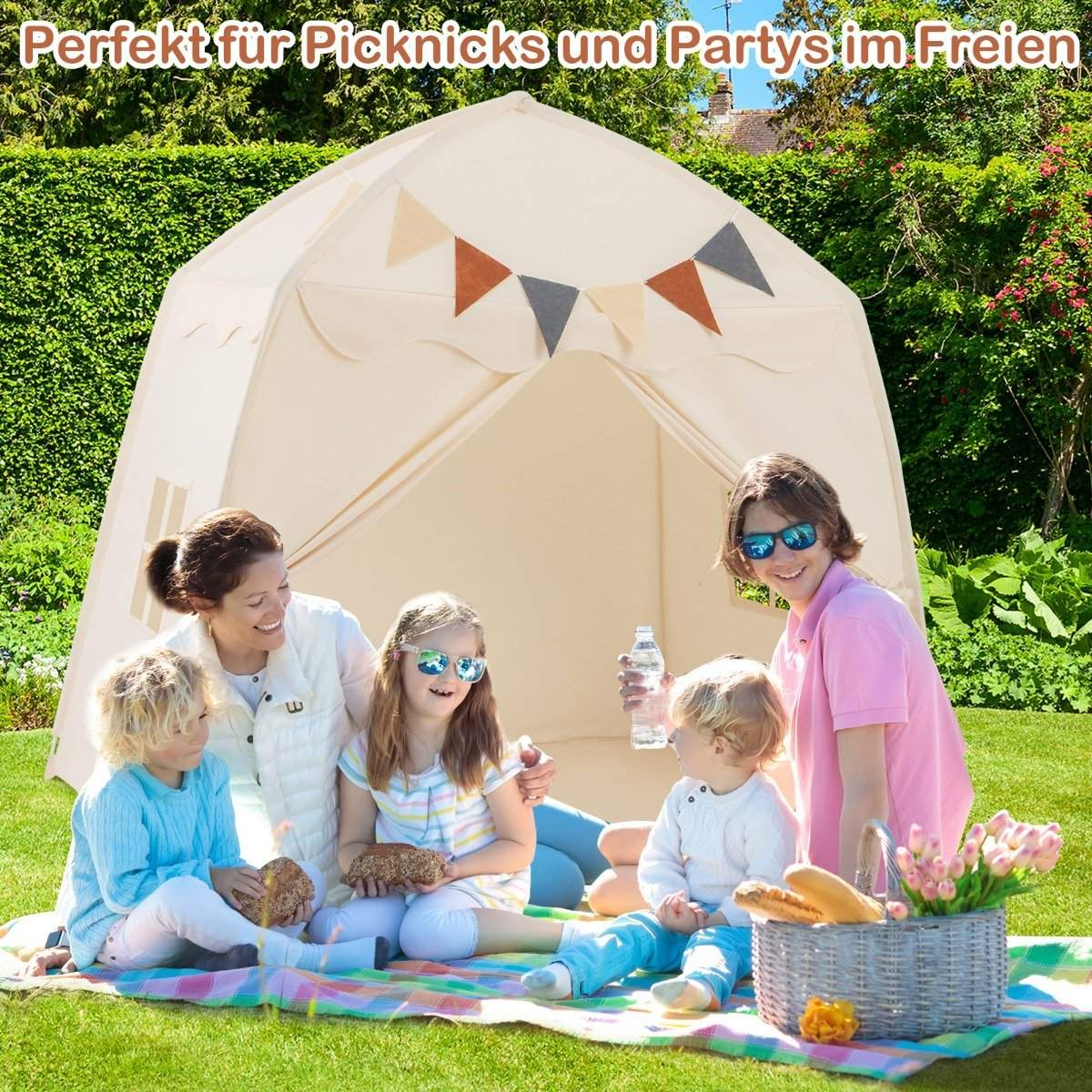 Familia haciendo un picnic frente a una carpa beige en un jardín. Se ven flores y pan.