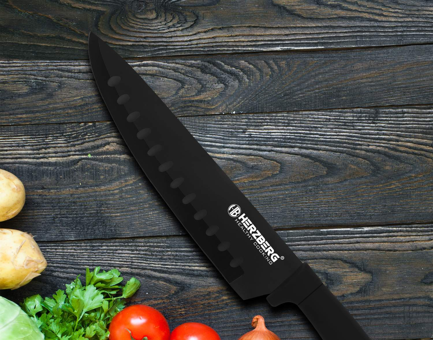 Cuchillo negro con hendiduras sobre mesa de madera con patatas, tomates, perejil y cebolla.