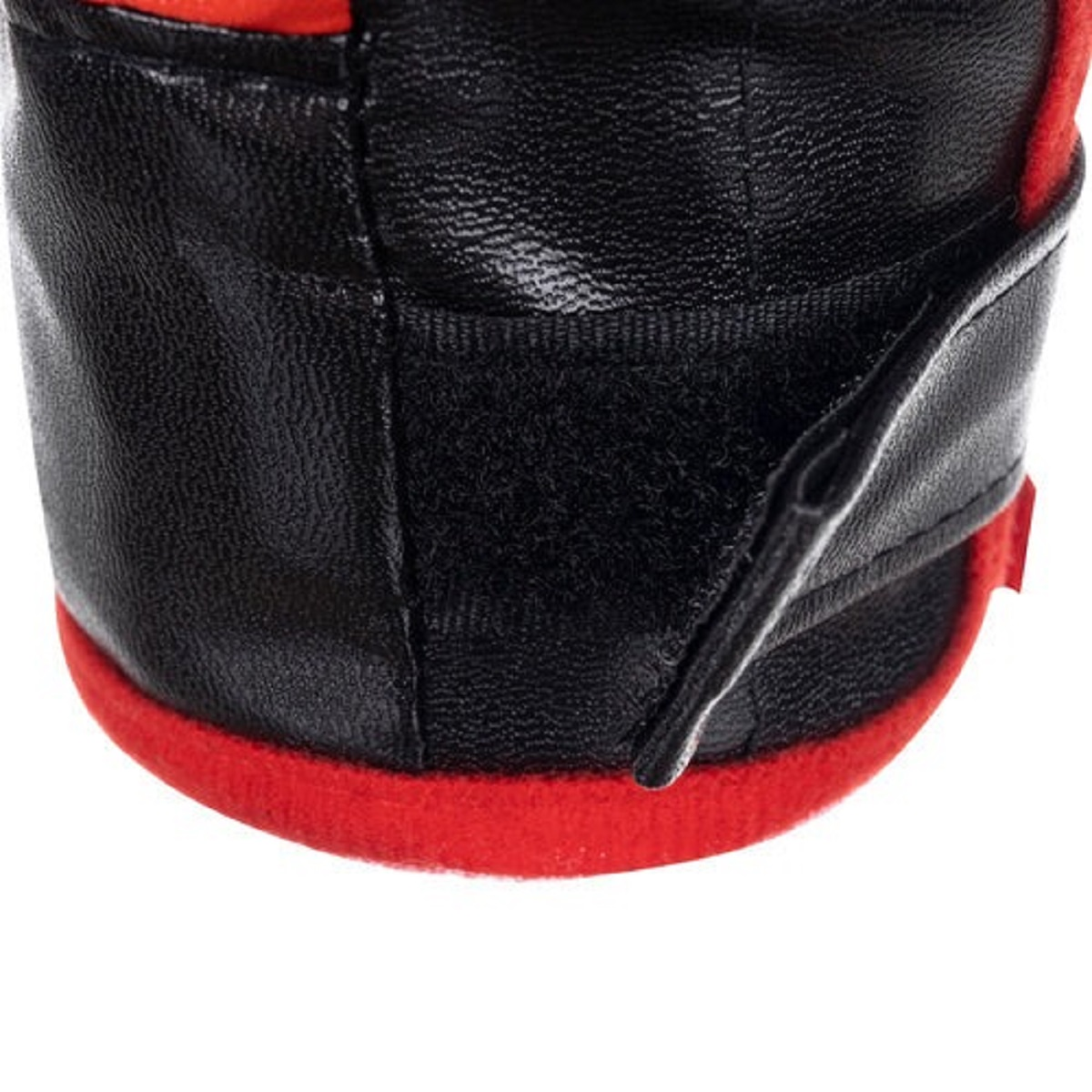 Primer plano de un guante negro con borde rojo y correa de velcro.