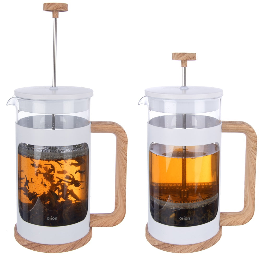 Dos cafeteras de prensa francesa con asas de madera, una con té suelto, la otra con té infusionado.