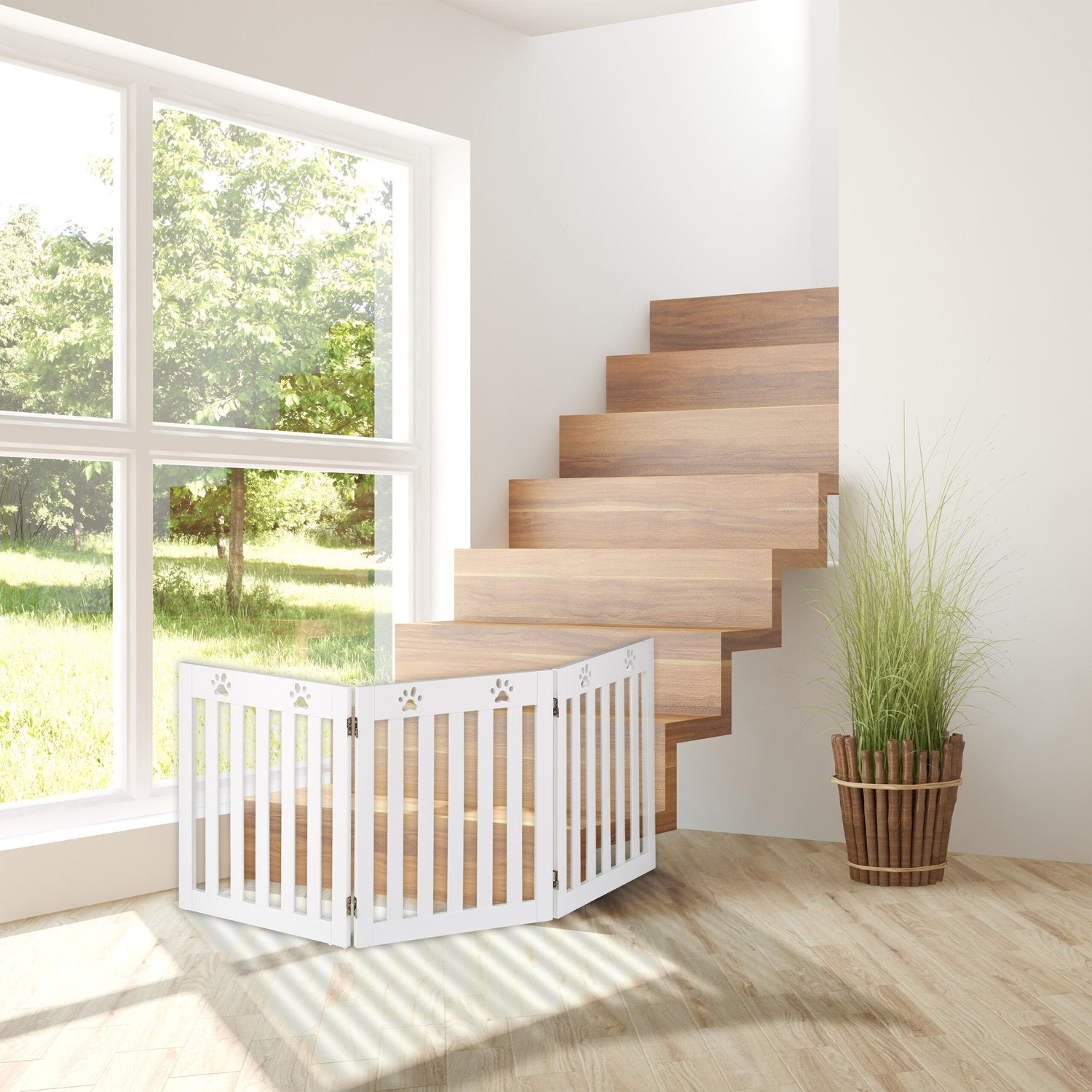 Una barrera blanca para mascotas con huellas de patas frente a una escalera de madera.