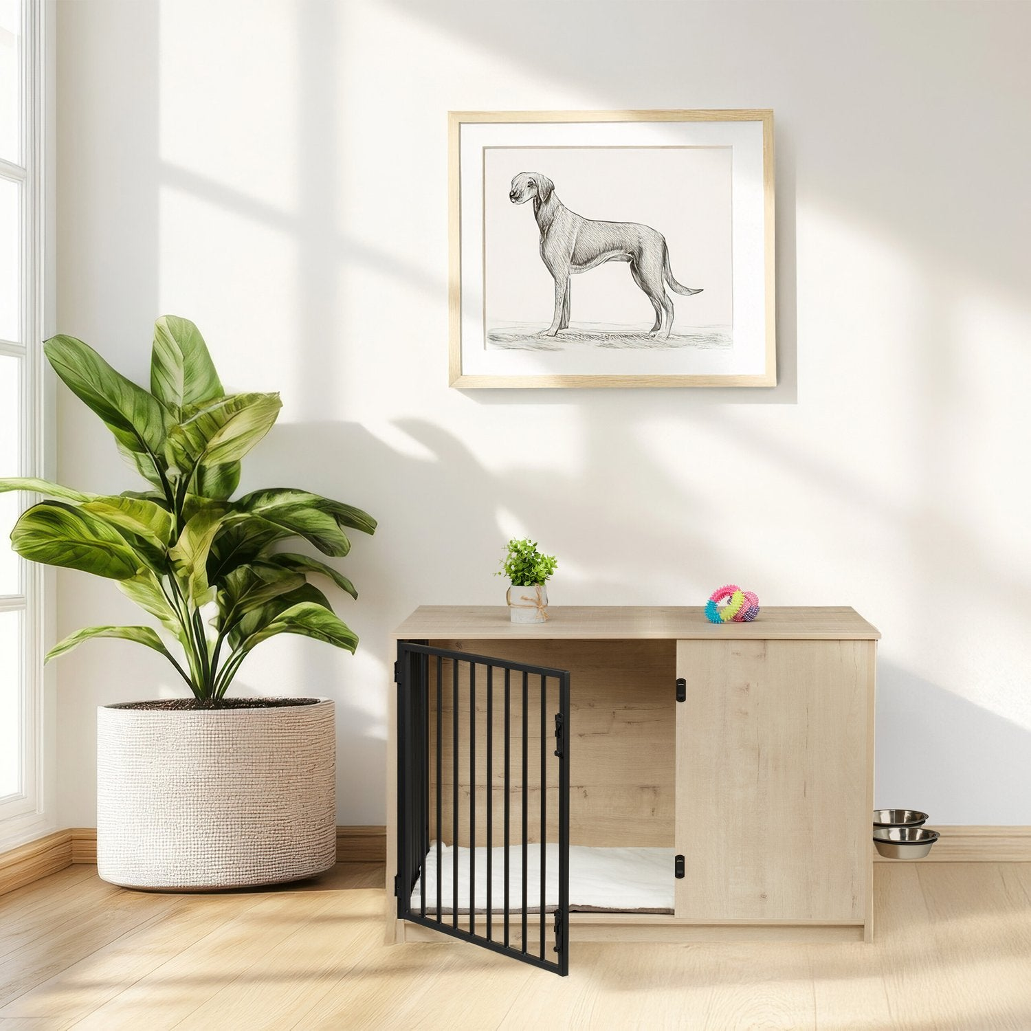 Una jaula para perros con puerta abierta, una planta y un cuadro de perro.