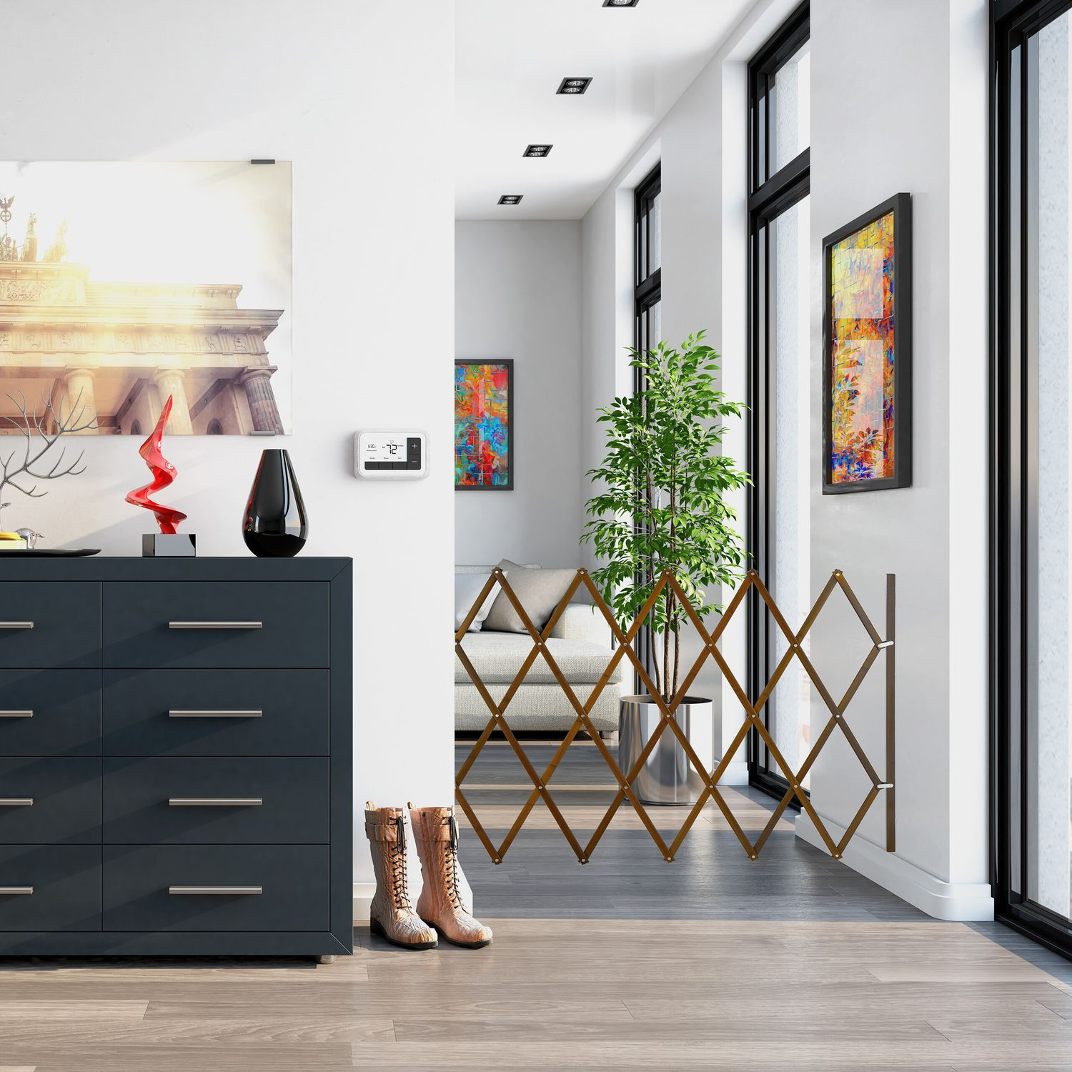 Cómoda gris oscura con arte, botas y puerta en un pasillo.
