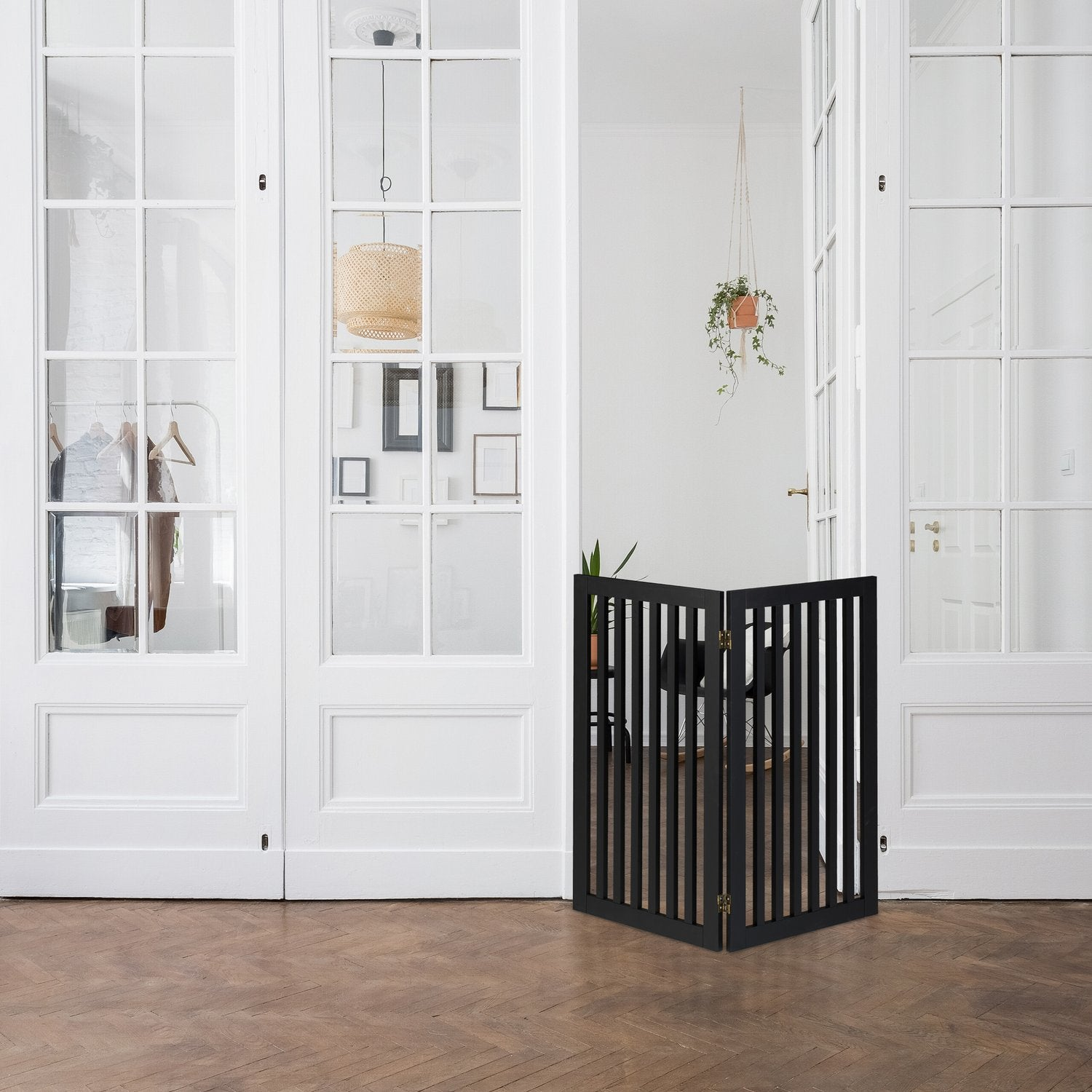 Una barrera de madera negra sobre suelo de parquet frente a puertas de cristal.
