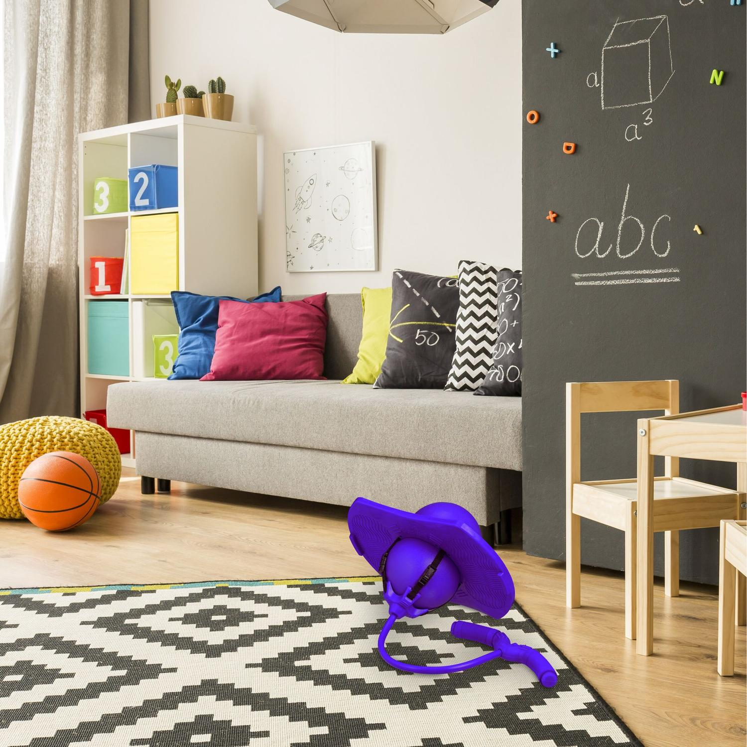 Habitación infantil con sofá, estantería, pizarra y juguetes.