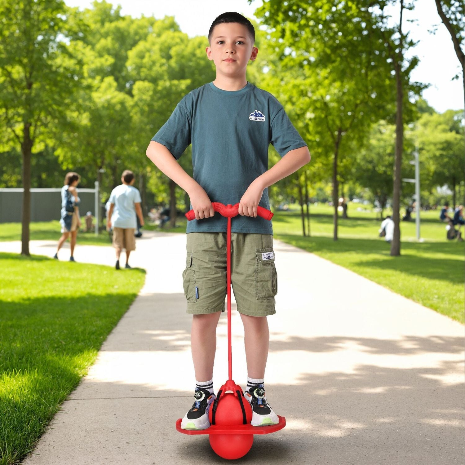 Un niño se para en un pogo stick rojo en un parque con árboles.