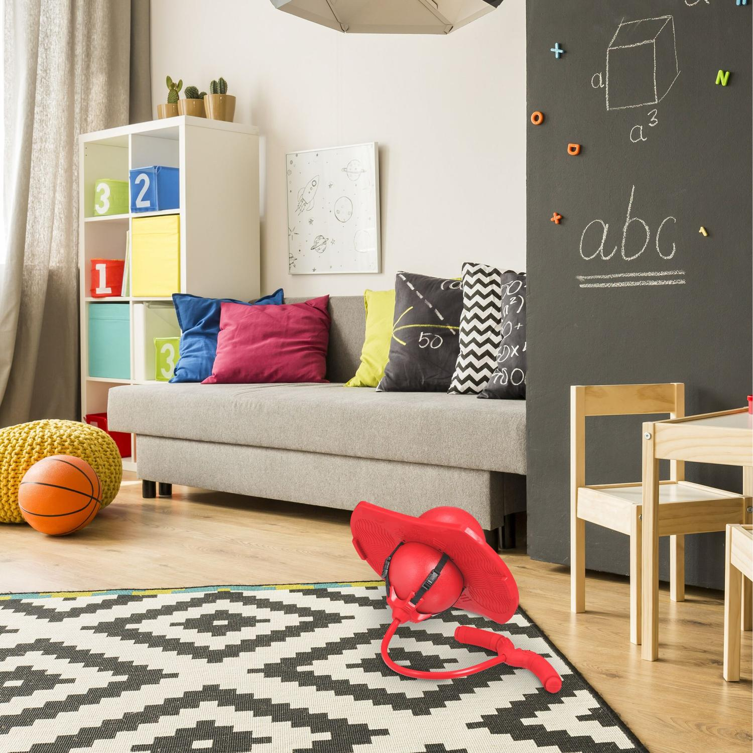 Habitación infantil con sofá, pizarra, juguetes y alfombra.
