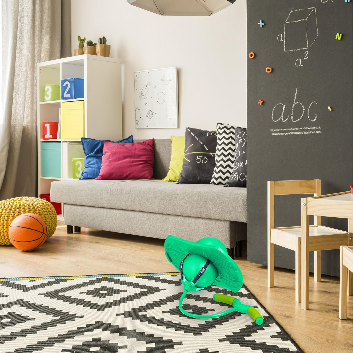 Habitación infantil con sofá, juguetes, pizarra y estantería.