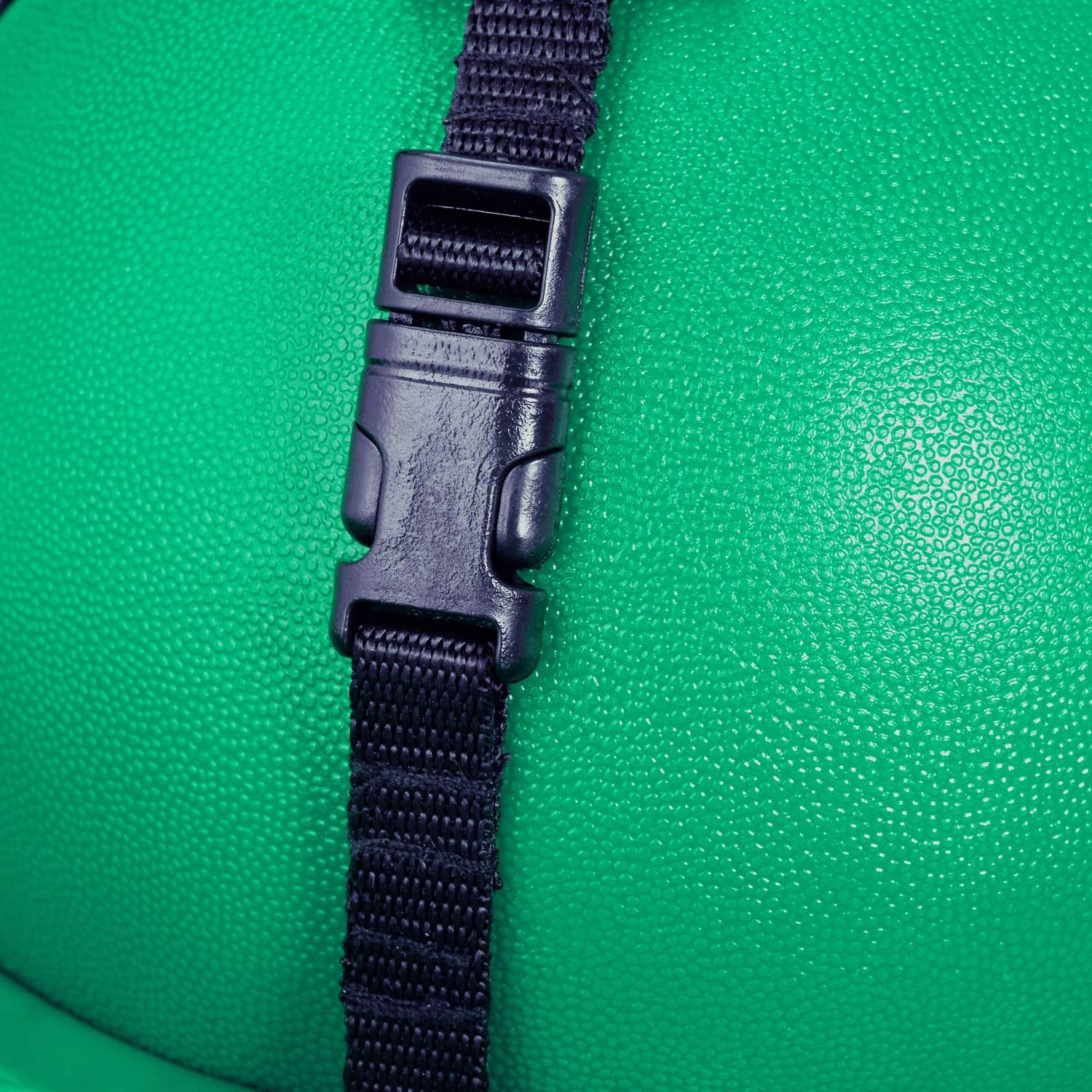 Una correa negra con hebilla sobre un fondo verde texturizado.